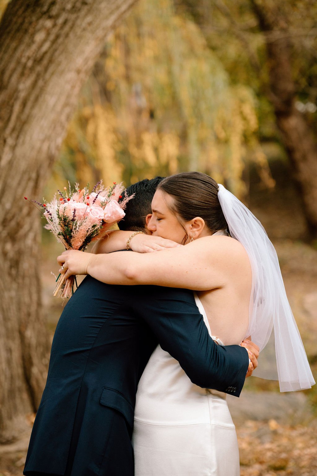 sweet couple hugging during their central park elopement during fall