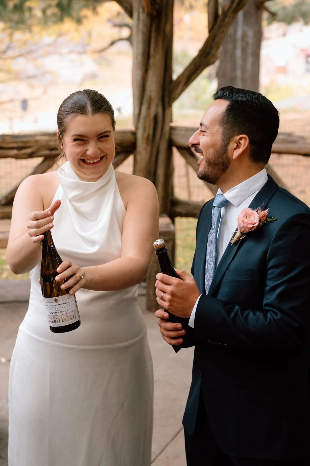 bride and groom popping champagne during after their central park elopement ceremony
