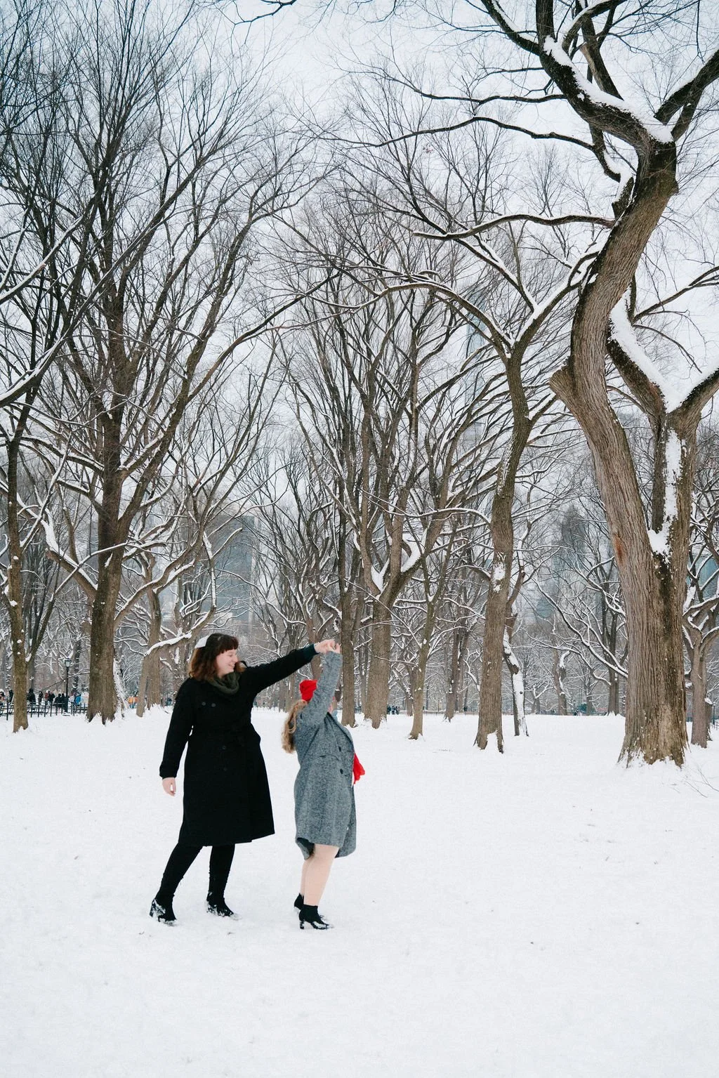 playful lesbian engagement photos in the snow at central park