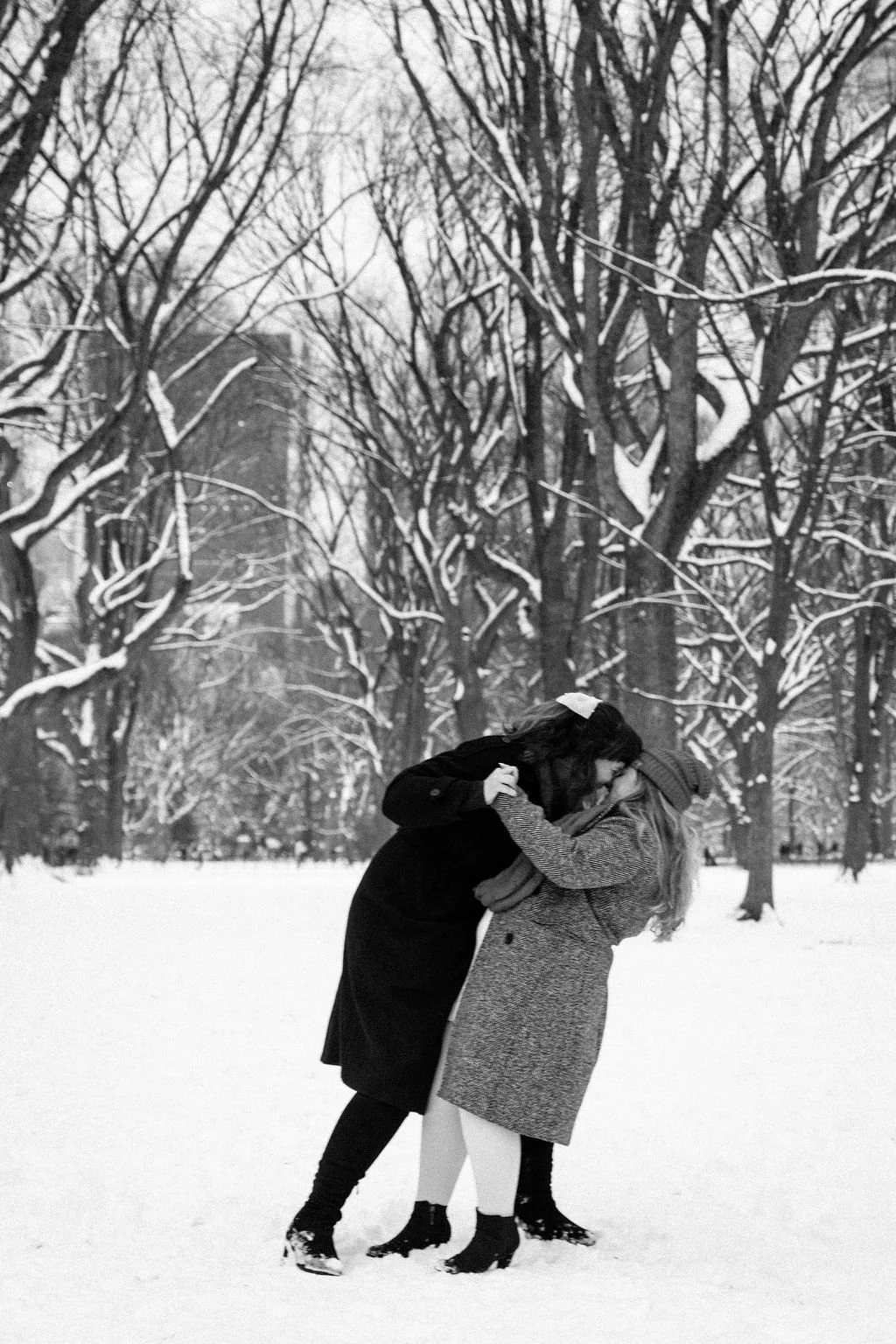 playful lesbian engagement photos in the snow at central park