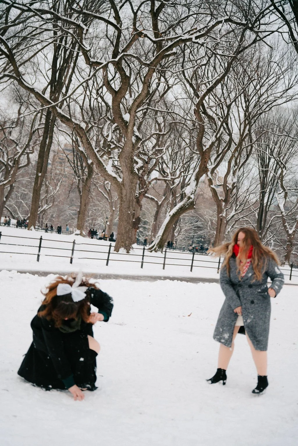 playful lesbian engagement photos in the snow at central park