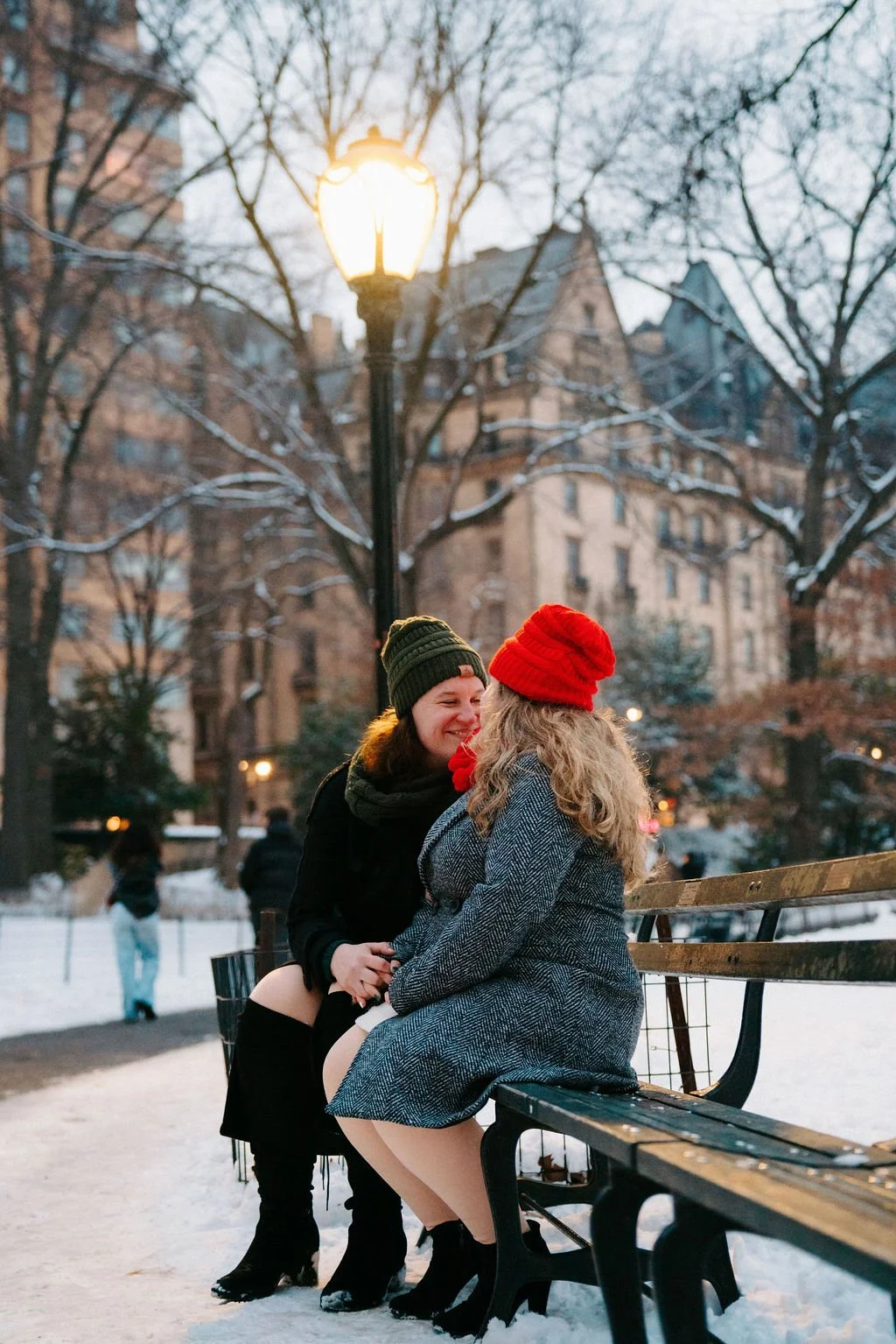 playful lesbian central park engagement surrounded by snowy landscapes