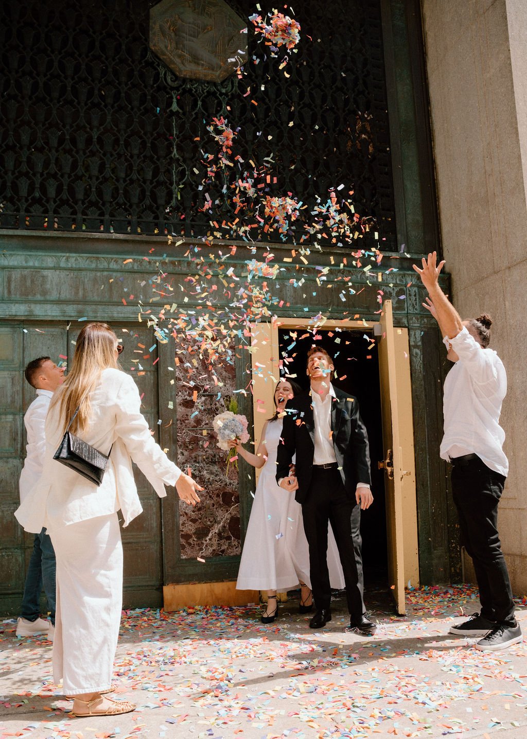 guests throwing confetti after an NYC city hall wedding ceremony
