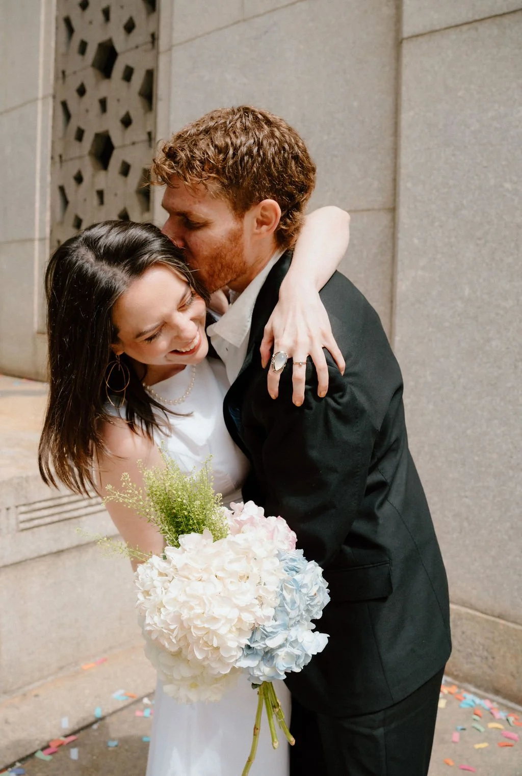 Couple embracing outside New York City Hall after their courthouse wedding