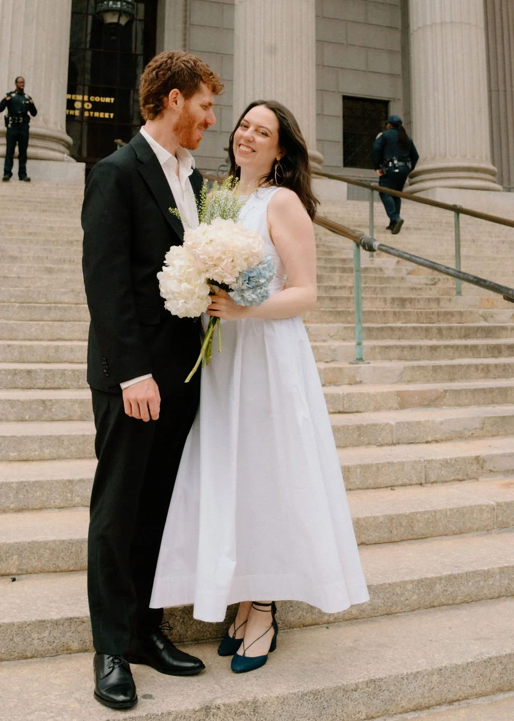 bride and groom posing on the steps of NYC city hall