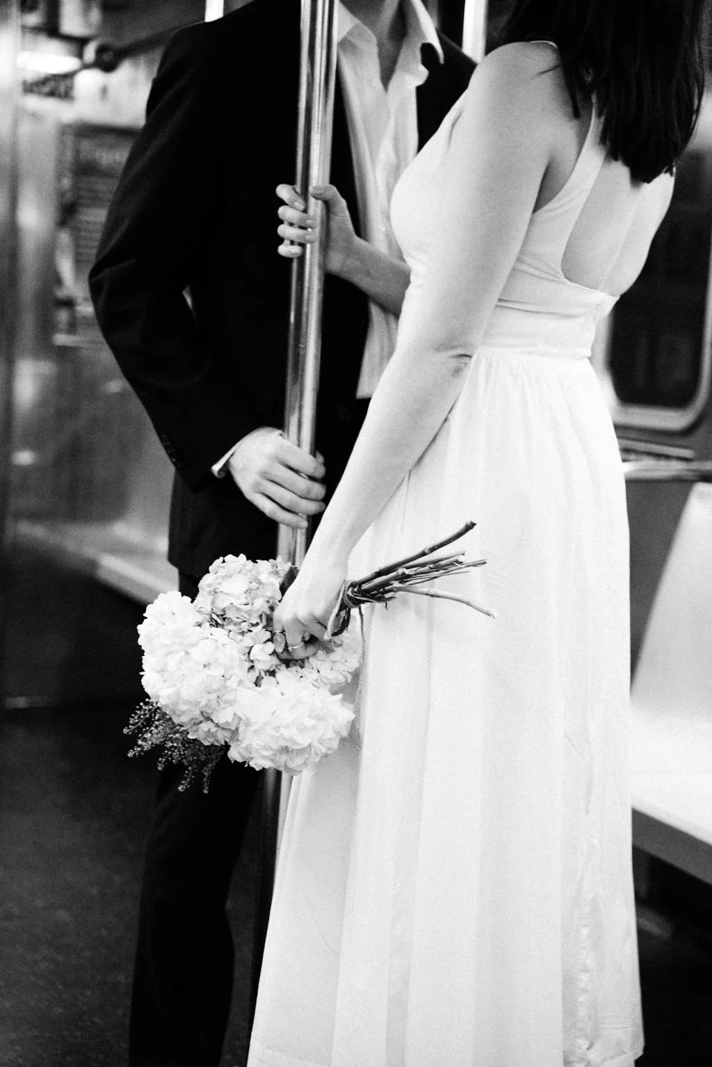Bride and groom riding the New York City subway after their intimate wedding