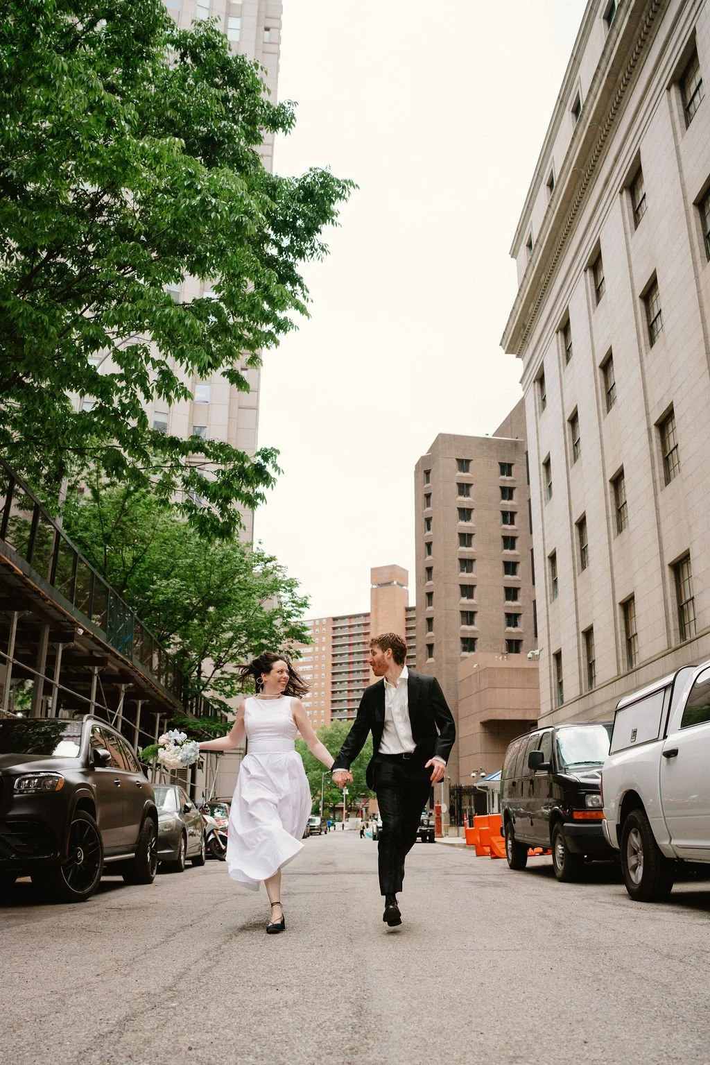 Bride and groom walking through Lower Manhattan following their NYC City Hall wedding