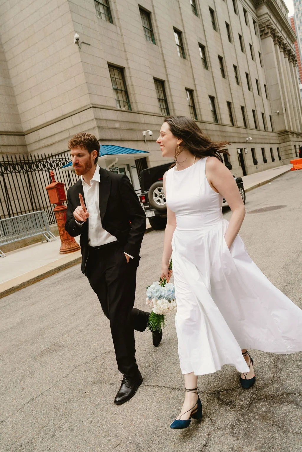 Bride and groom walking through Lower Manhattan following their NYC City Hall wedding