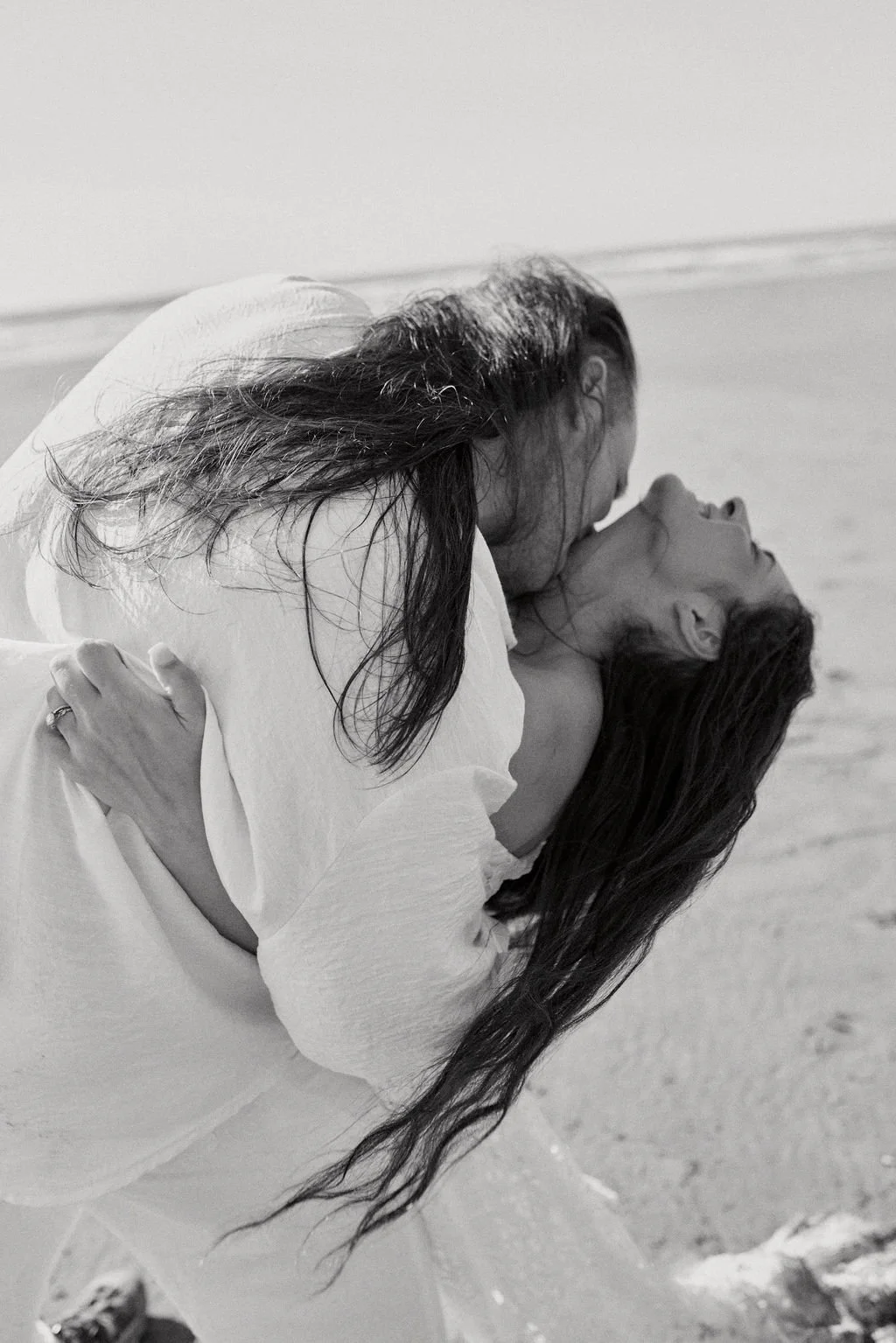 playful newlyweds along the coast of ruby beach during golden hour