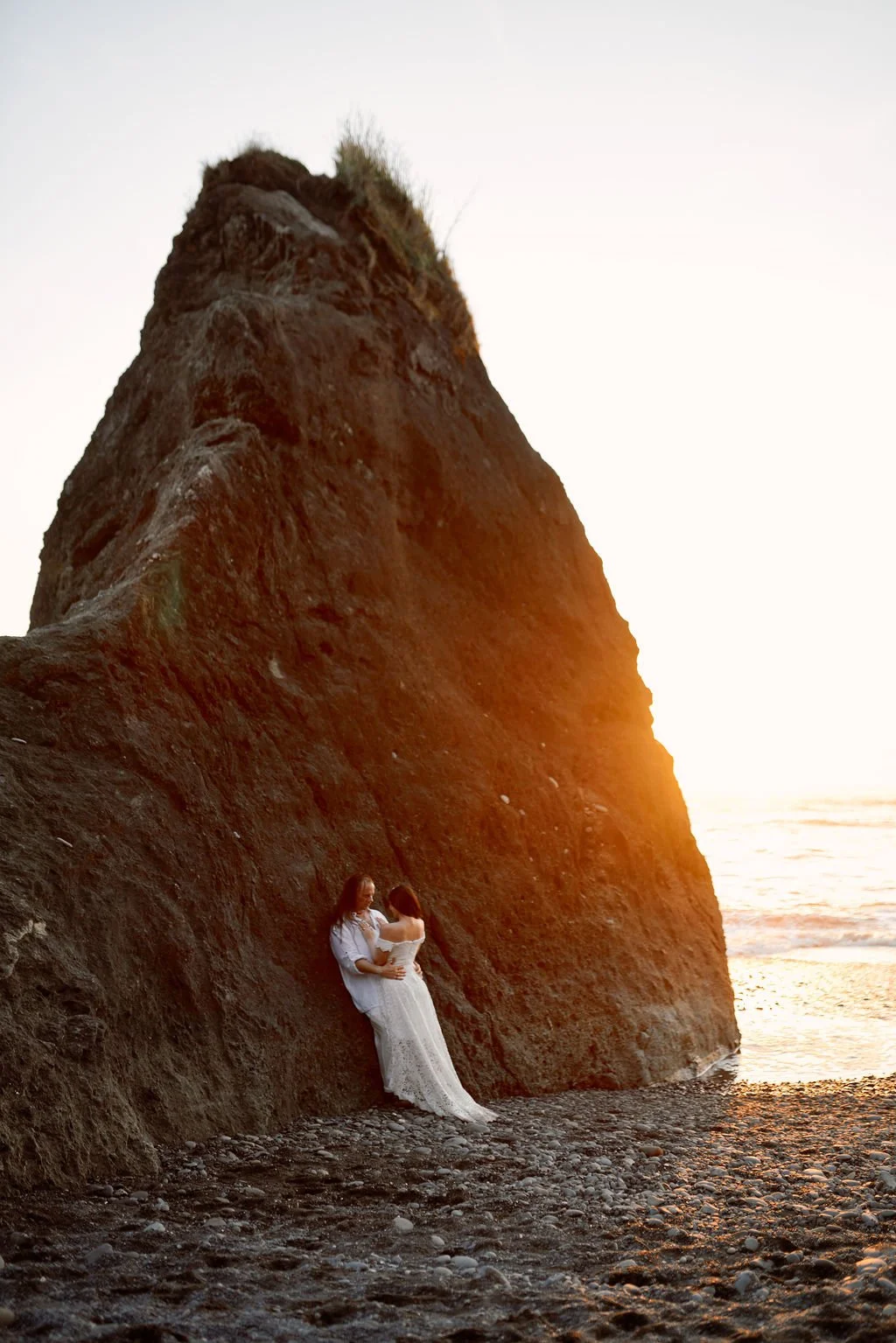 playful newlyweds along the coast of ruby beach during golden hour