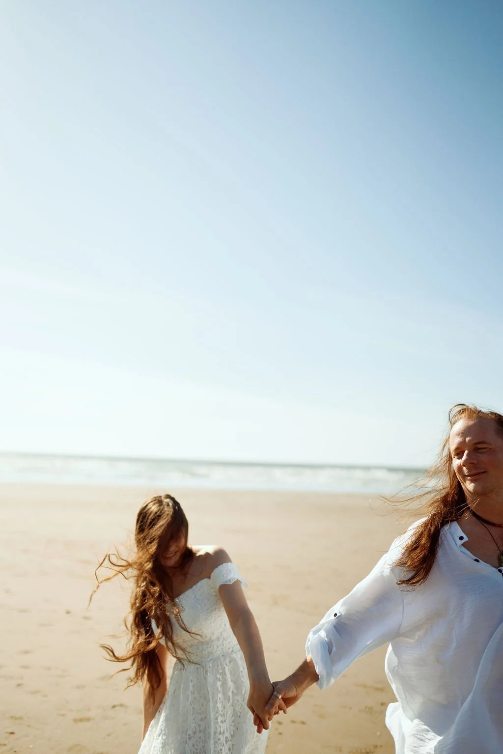 playful newlyweds along the coast of ruby beach during golden hour