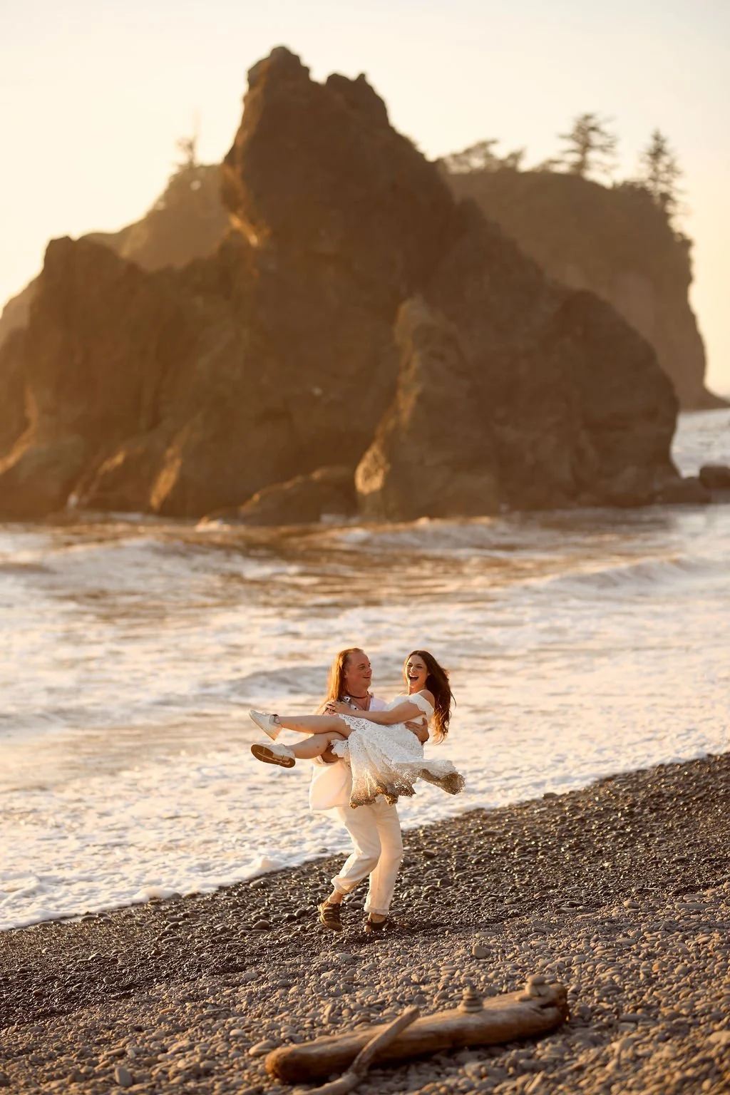 playful newlyweds along the coast of ruby beach during golden hour