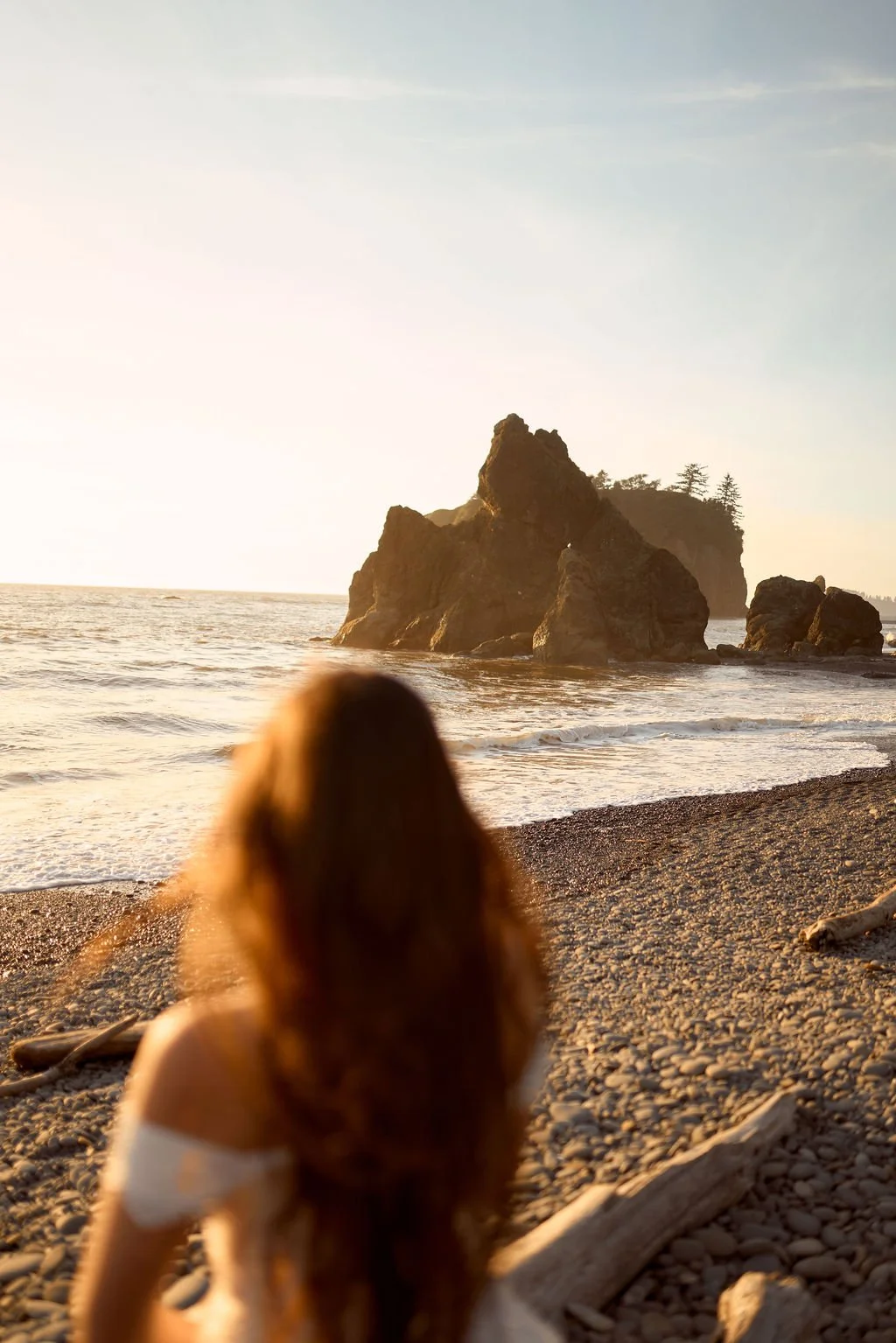 playful newlyweds along the coast of ruby beach during golden hour