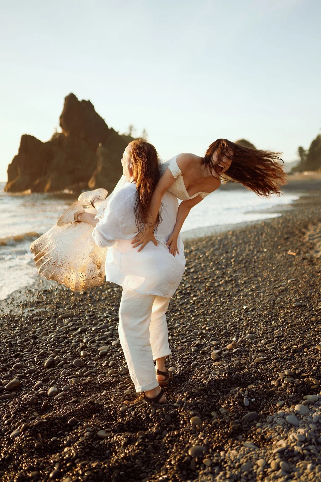 playful newlyweds along the coast of ruby beach during golden hour