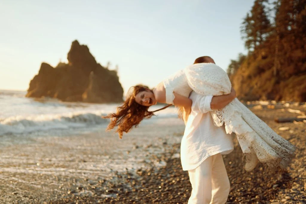 playful newlyweds along the coast of ruby beach during golden hour