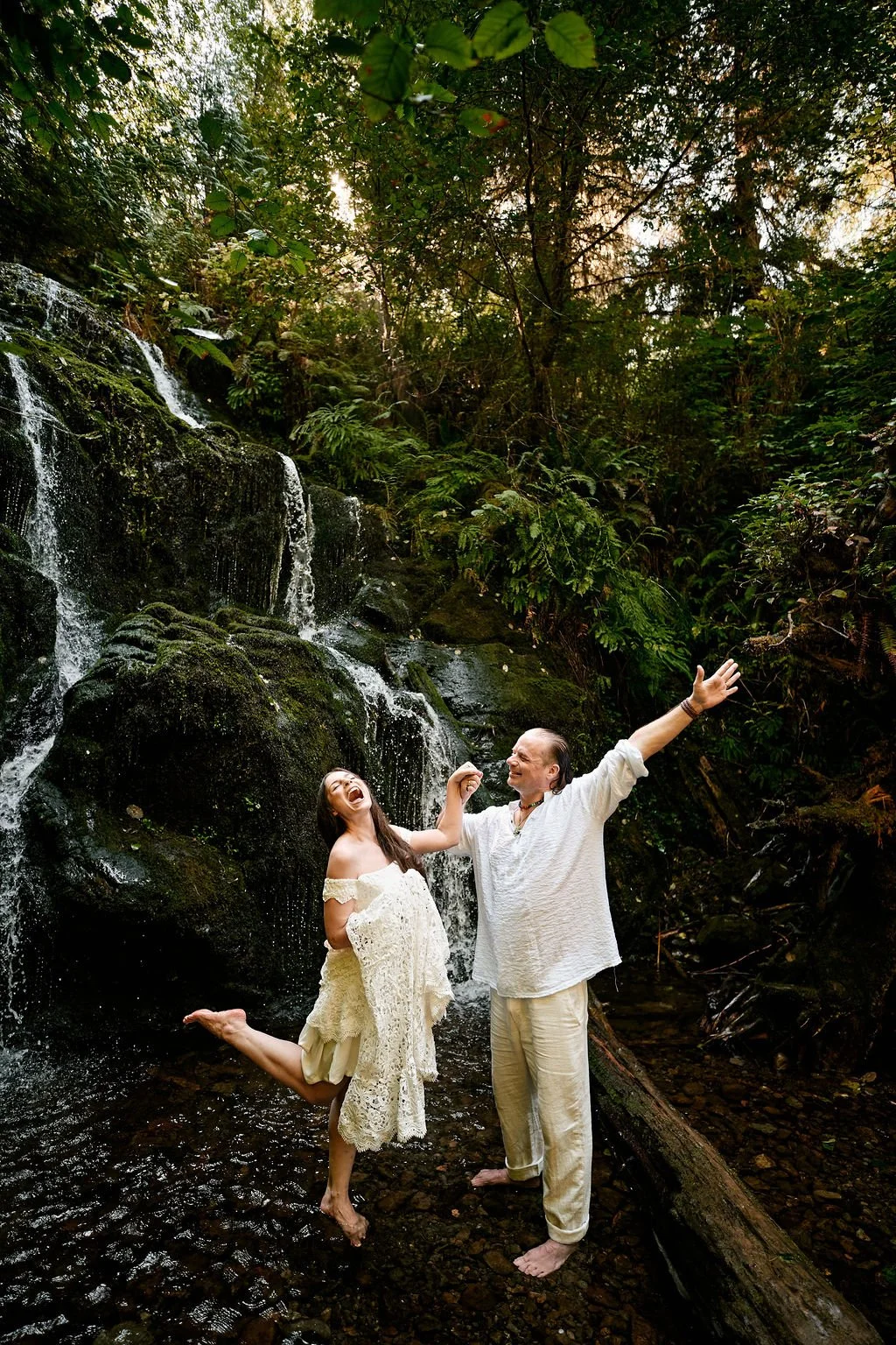 couple exchanging private vows at the base of a small waterfall in quinault rainforest