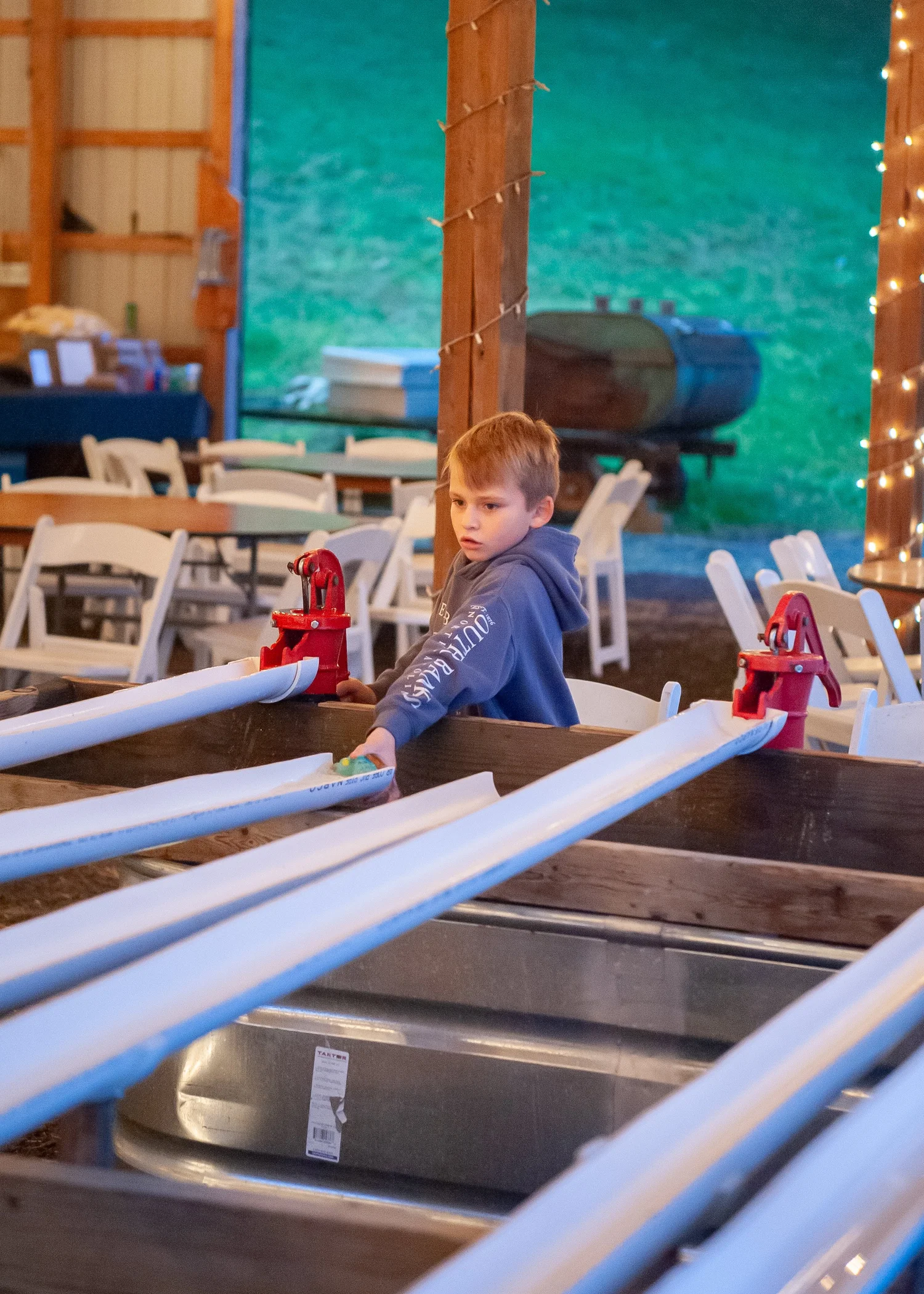 A boy racing rubber ducks down the water chutes