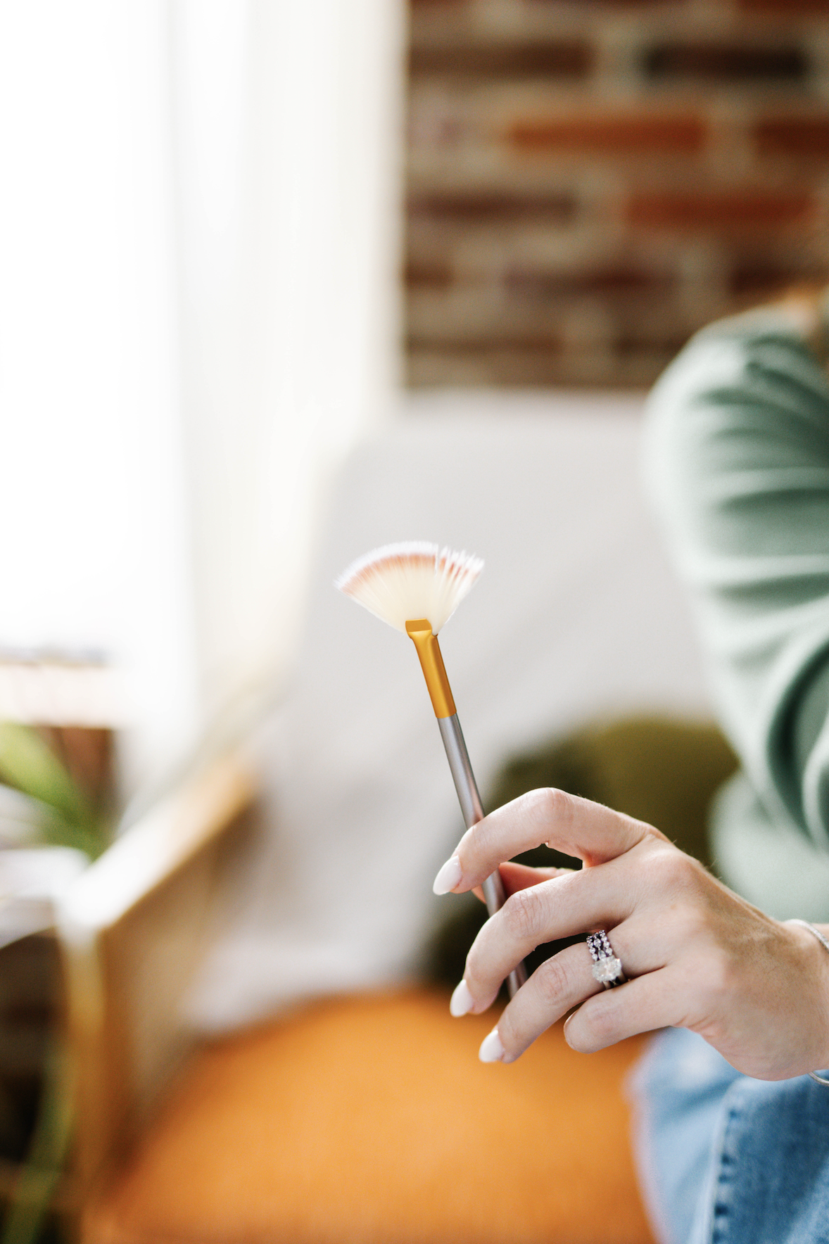 Person holding a small cleaning brush with a long handle, possibly for cleaning delicate items.