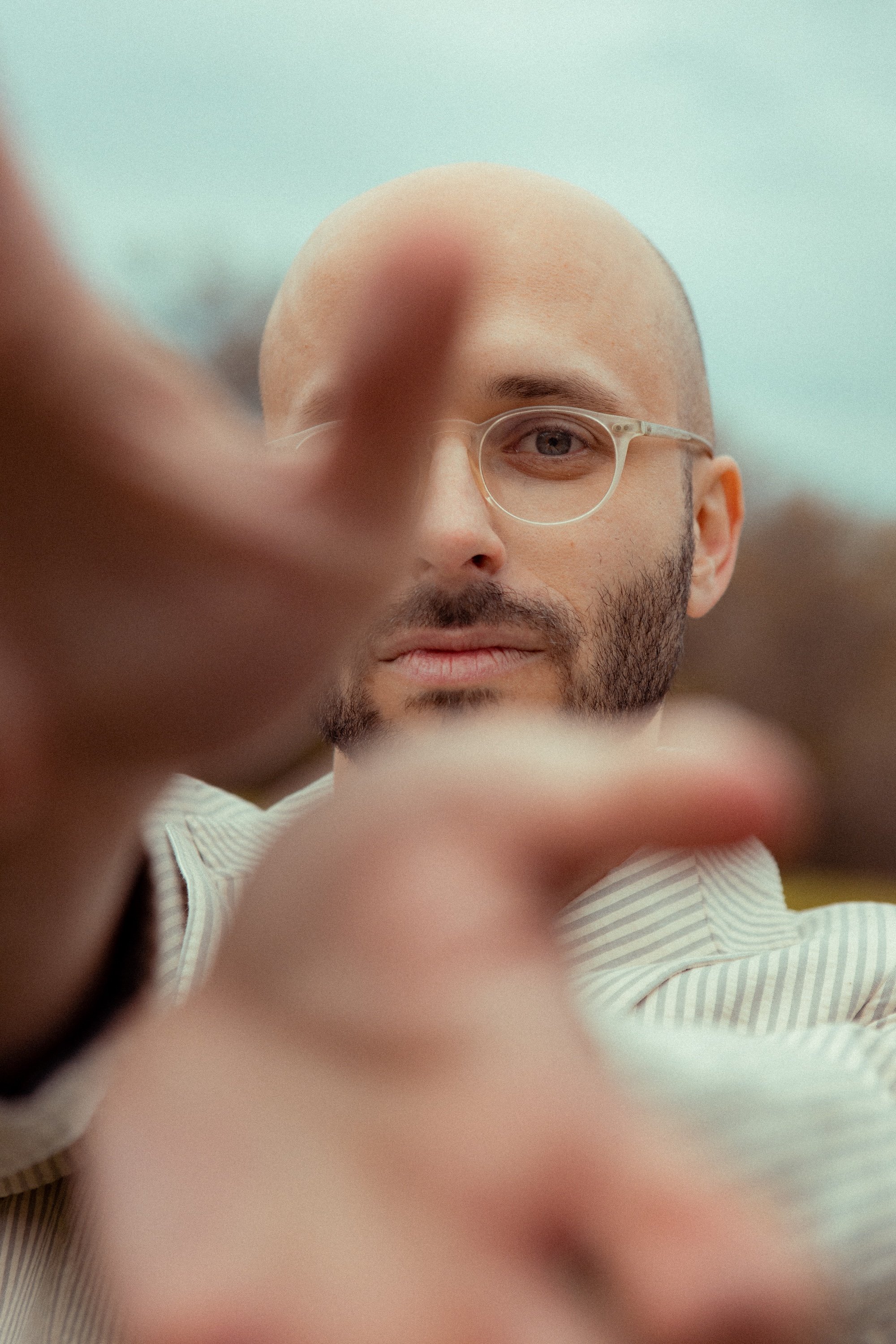 Close-up of Alec Hutson, Warbird Creative founder, with a beard wearing glasses and a striped suit