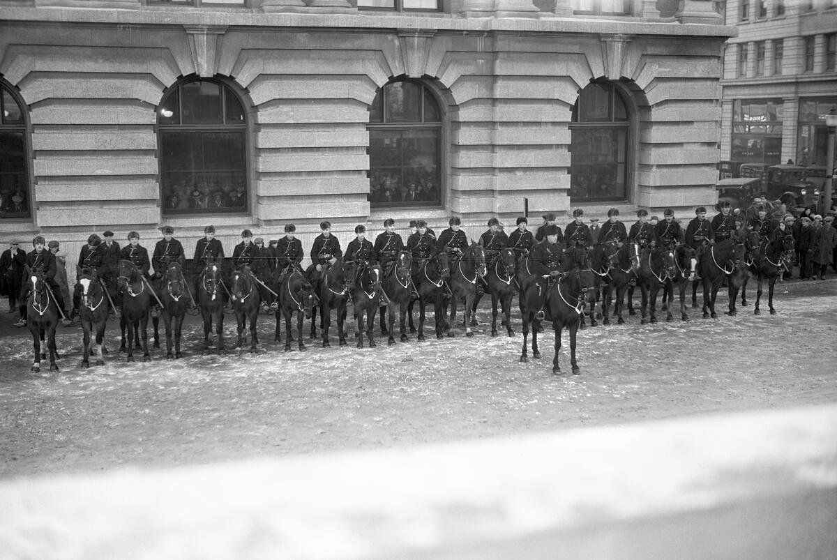  Troopers of the R.C.M.P.’s G-Division shortly before the Marchers set off. A crowd watches from inside.   Glenbow Archives Photo No. NC-6-13014I  