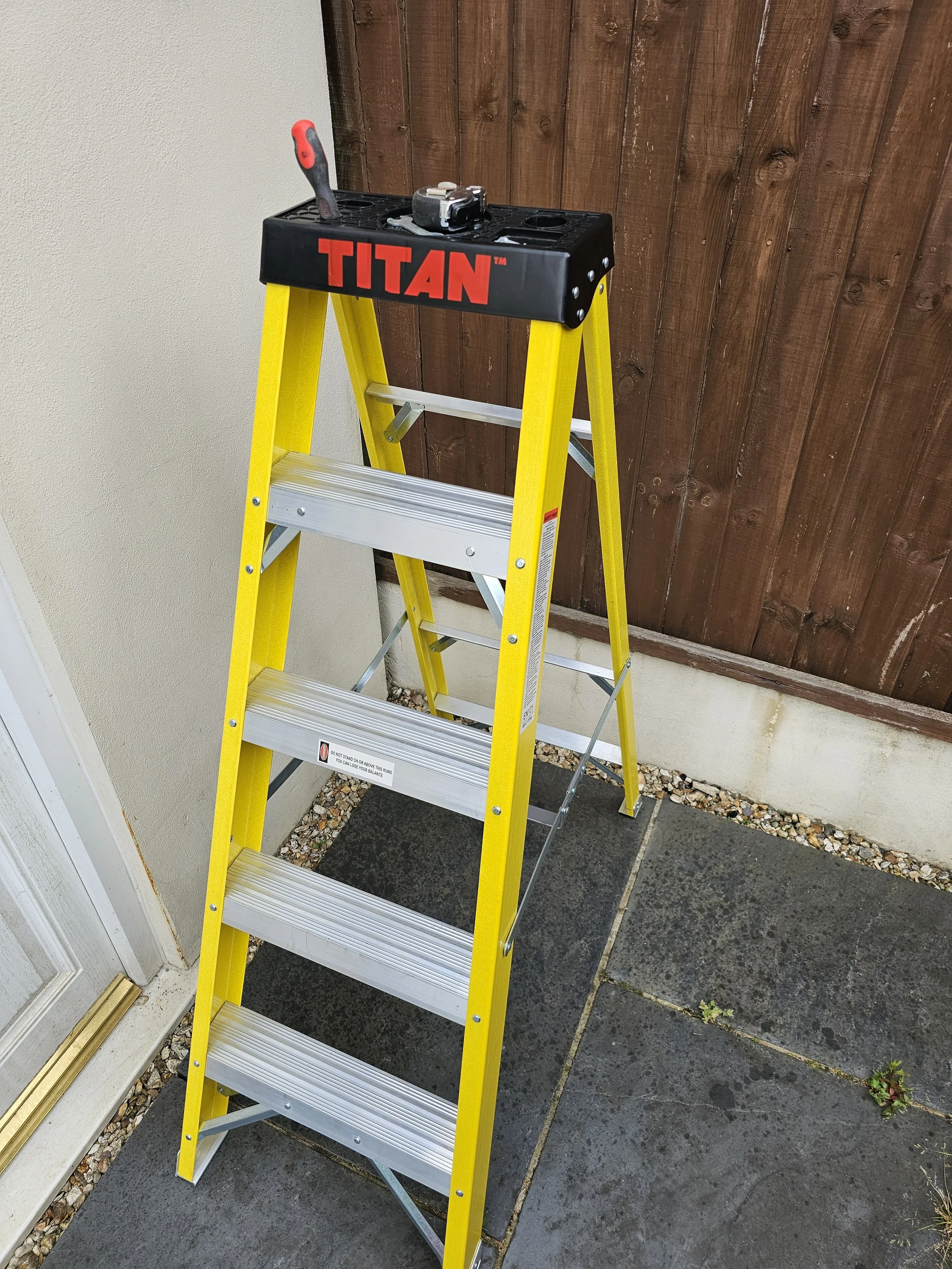 Step ladder for outdoor maintenance with tools in tool tray