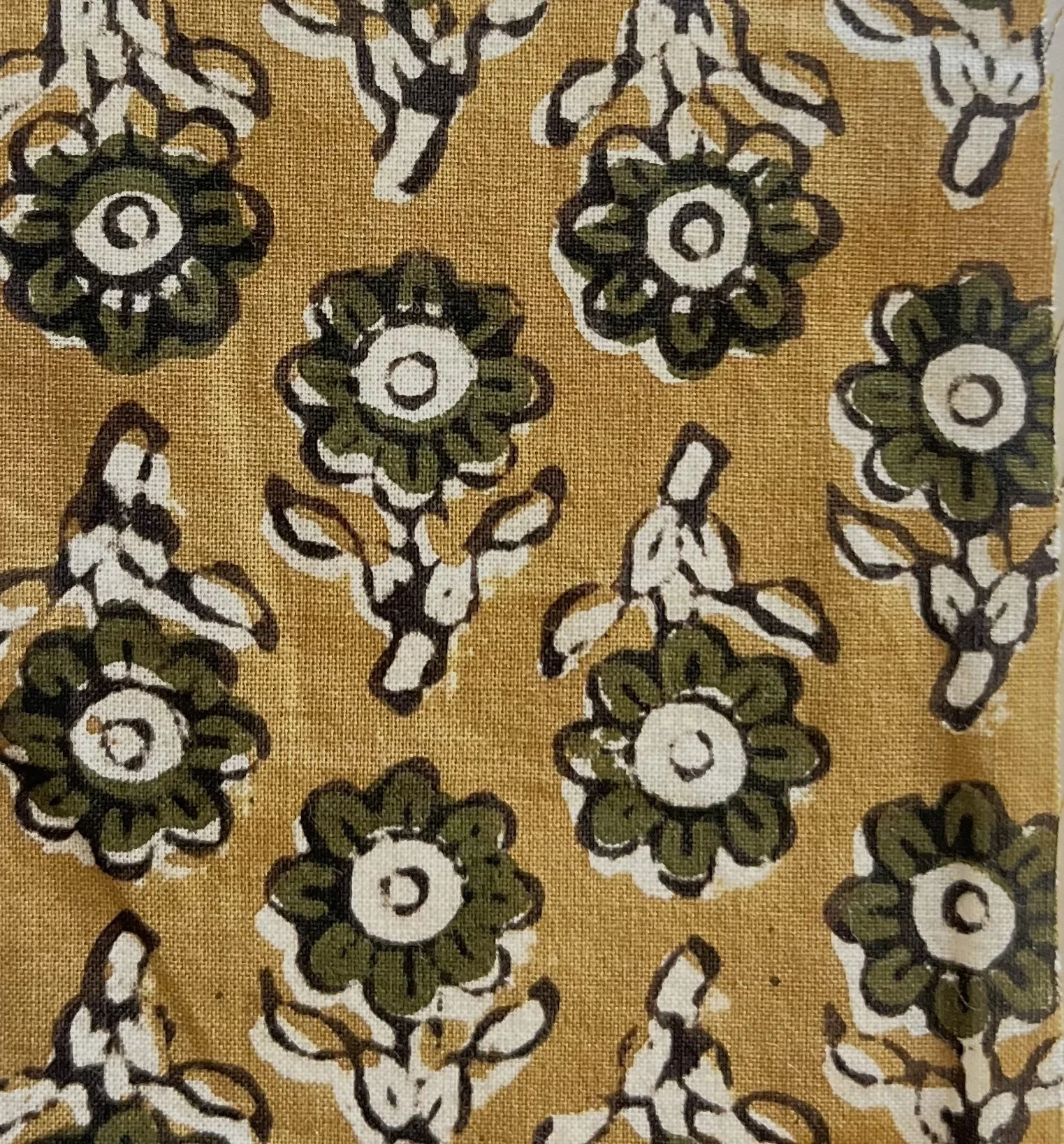 Pattern of green and white flowers on a yellow background.