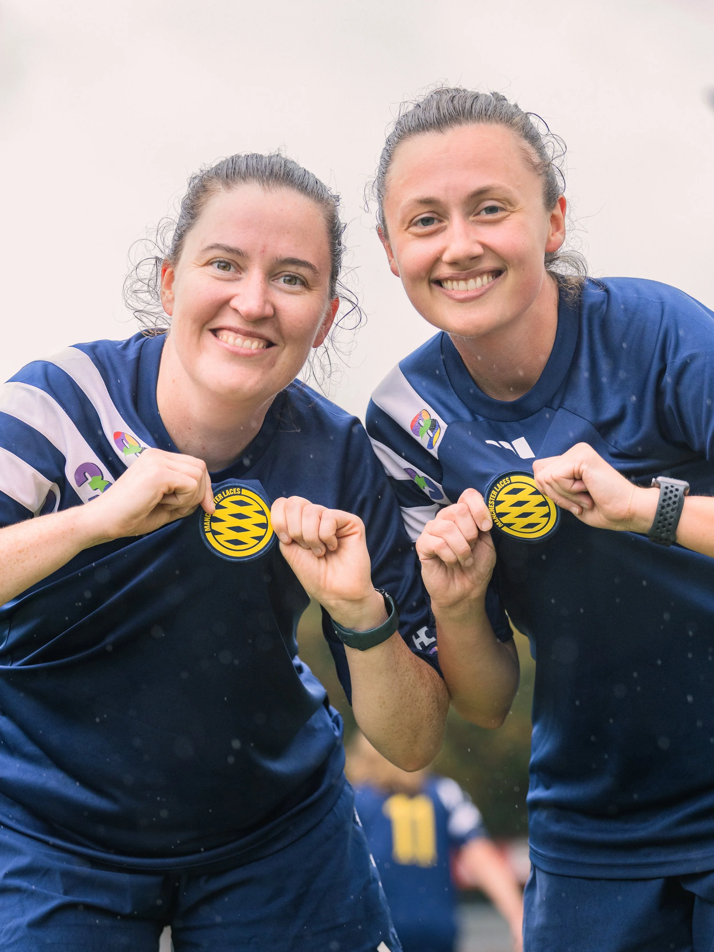 two players showing off the Manchester Laces badge on their match shirts