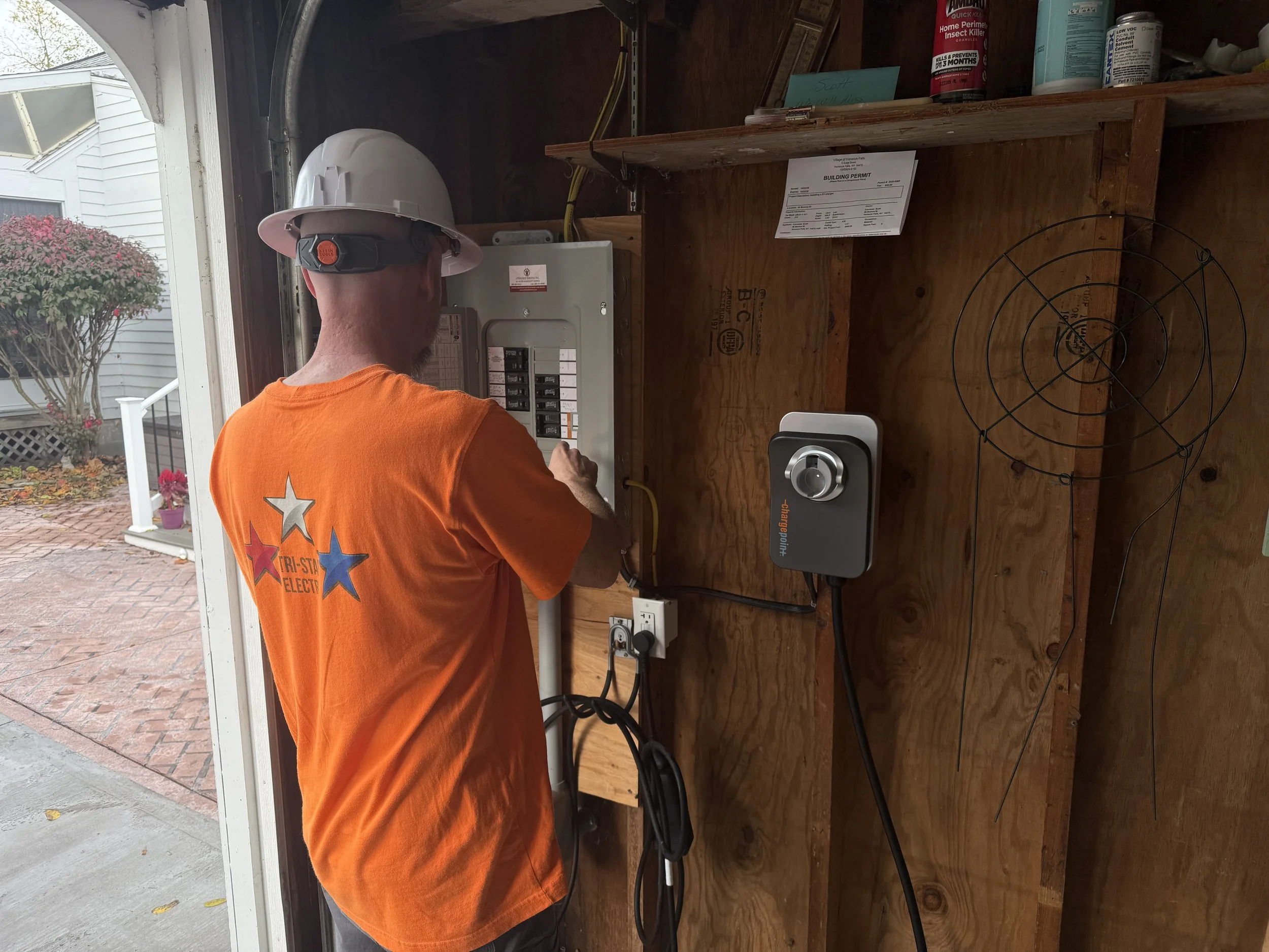 One of Tri-Star Electric's licensed master electricians installing a level 2 Charge Point EV charger in a customer's garage.