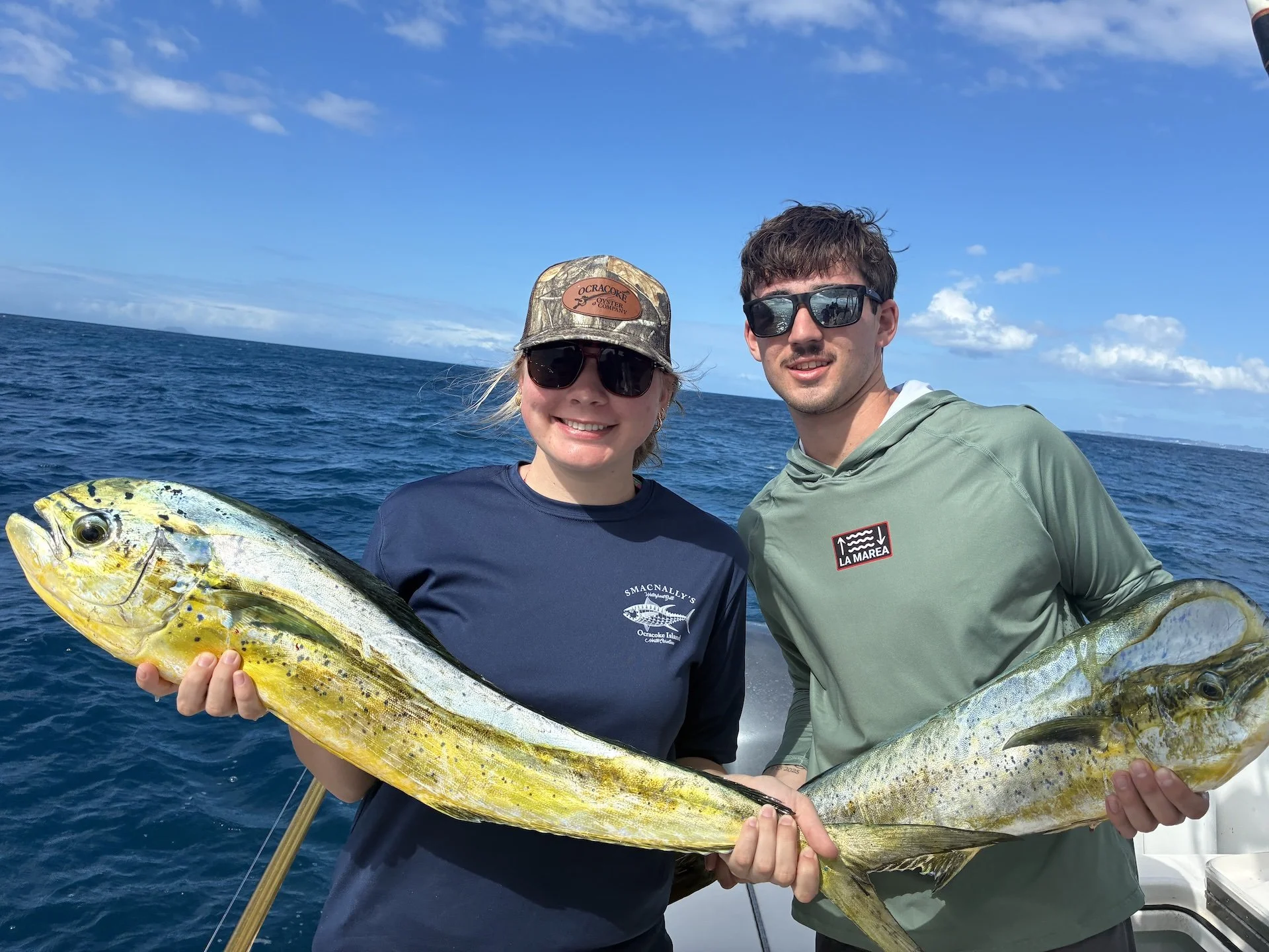 Familias que disfrutan de una aventura de pesca de dos días y sostienen dorados frente a la costa de Aguadilla, en Puerto Rico