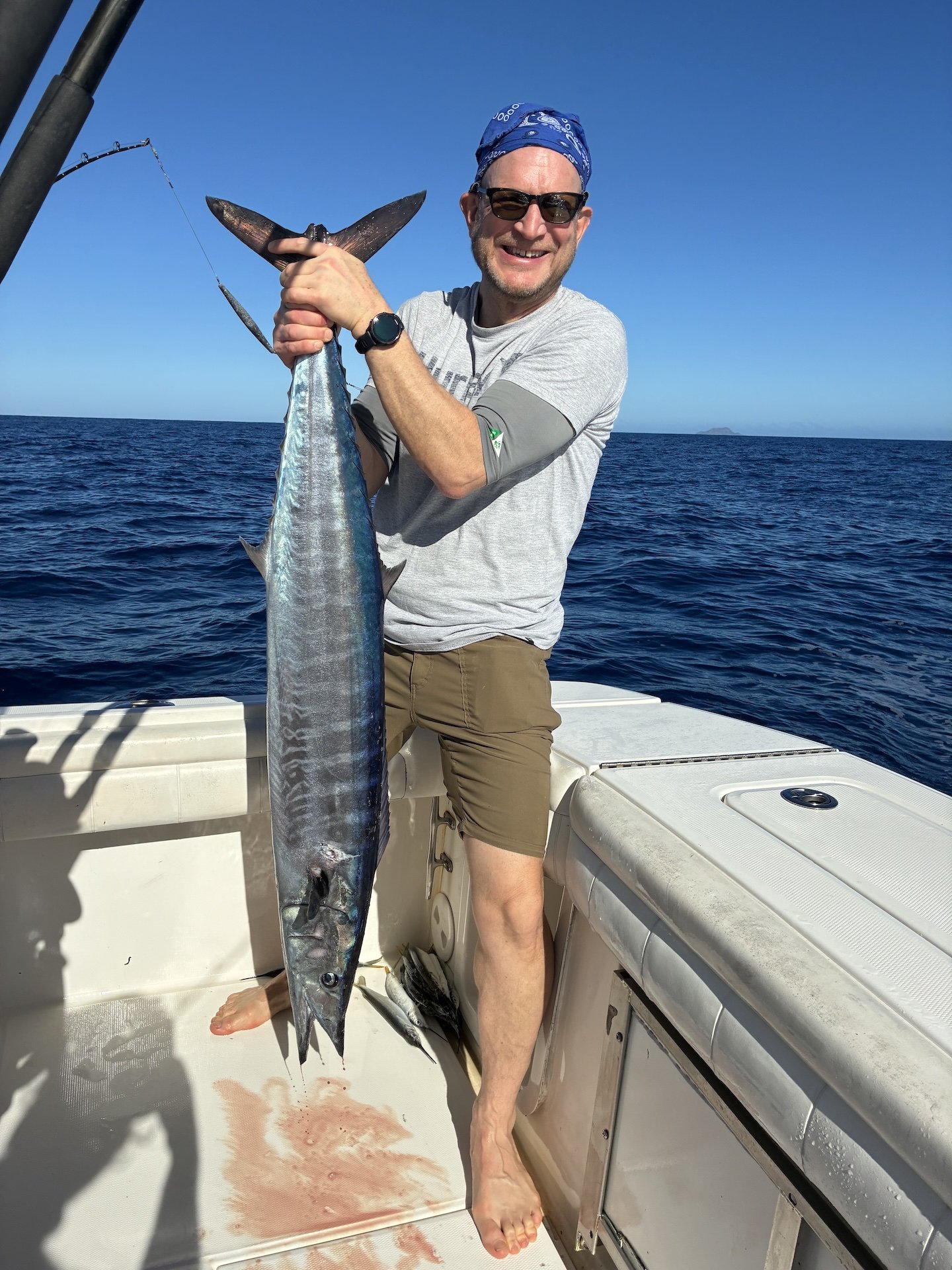Acción en cubierta a bordo del Simply Caught Charters, donde los pescadores se enfrentan a un wahoo de gran tamaño en aguas profundas.