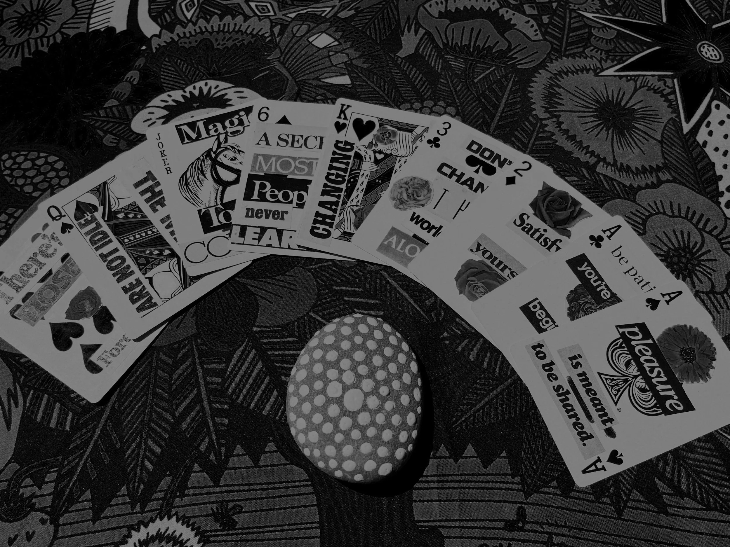 Oracle cards spread out above a painted rock