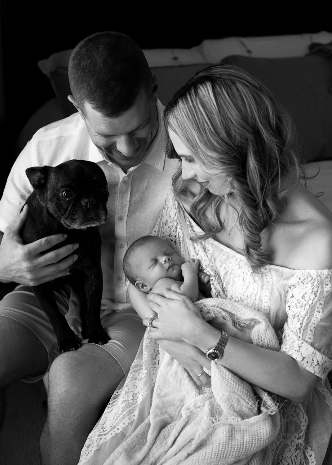 Newborn with parents and family dog a black pug