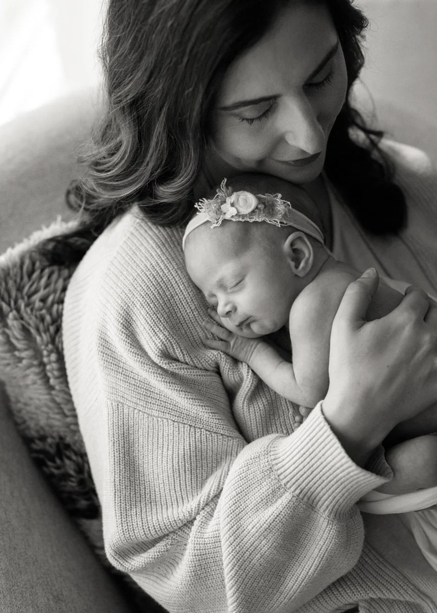 Mom holding newborn baby in natural lighting