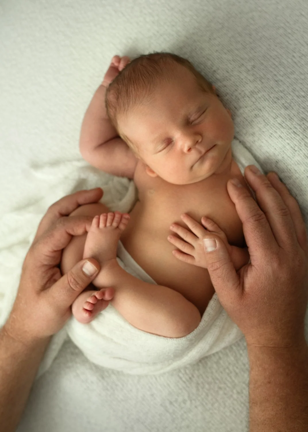 Sweet sleeping newborn half wrapped with one arm over head