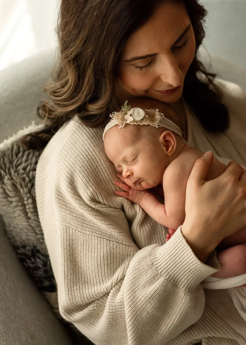 Mom holding newborn looking cozy and relaxed