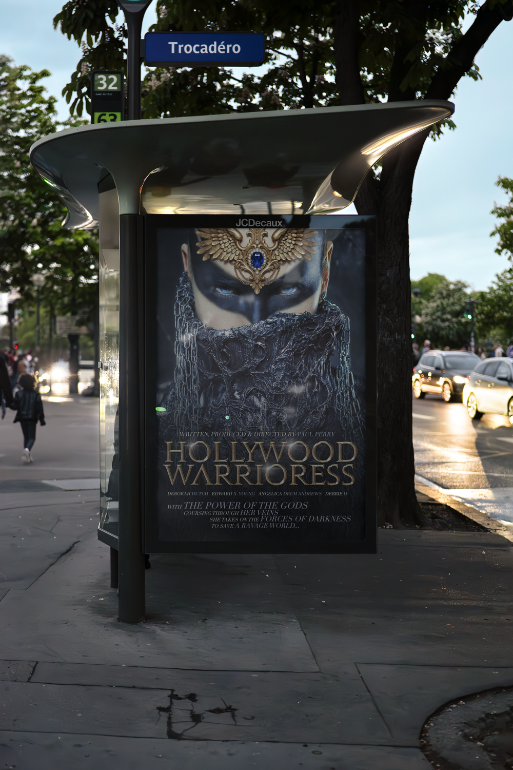 Bus stop shelter advertising the movie Hollywood Warrioress with a close-up of a fierce woman wearing an ornate headpiece and a dark, textured mask.