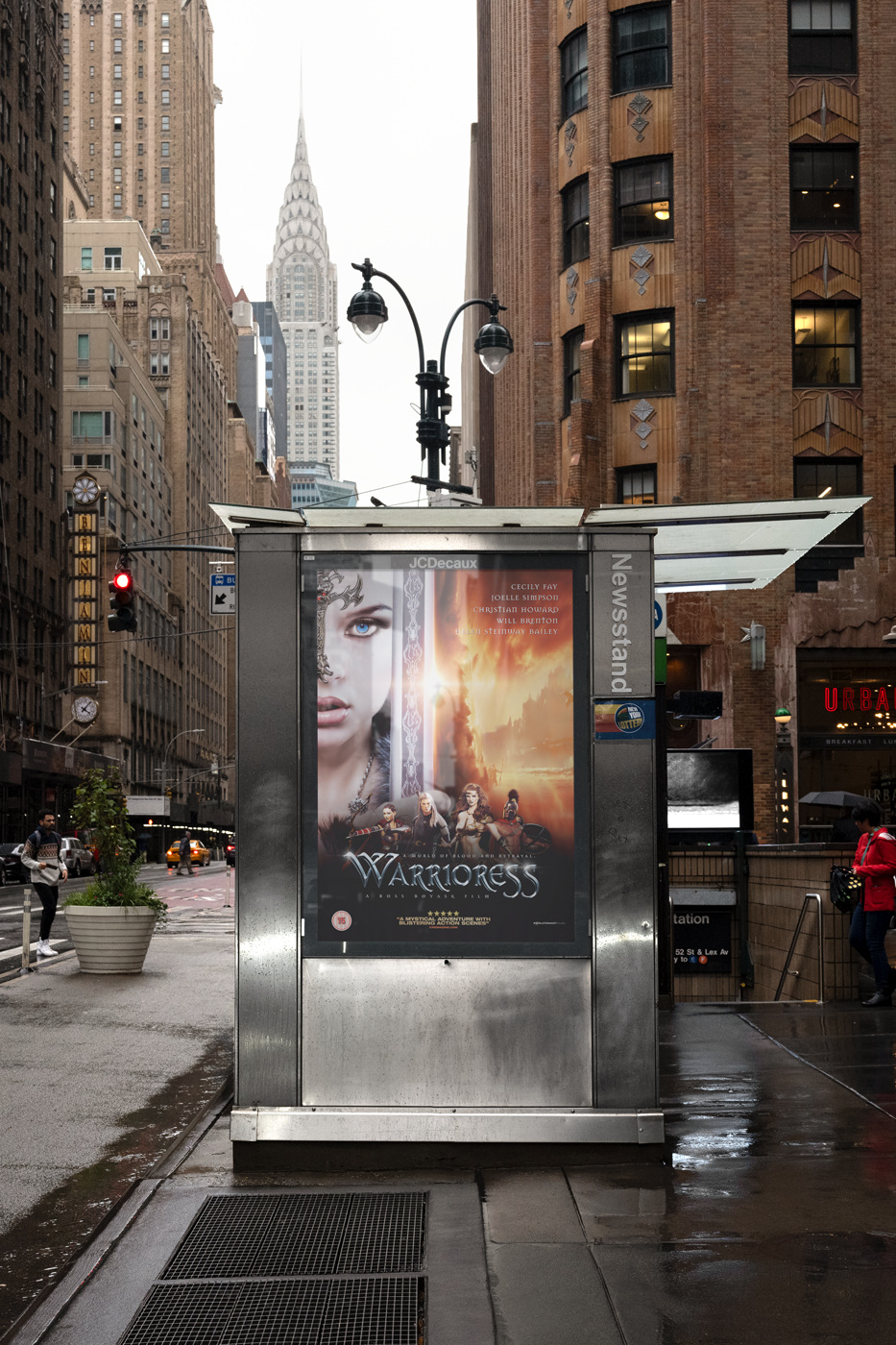 A city street scene on a cloudy day with tall buildings, a bus stop advertisement.