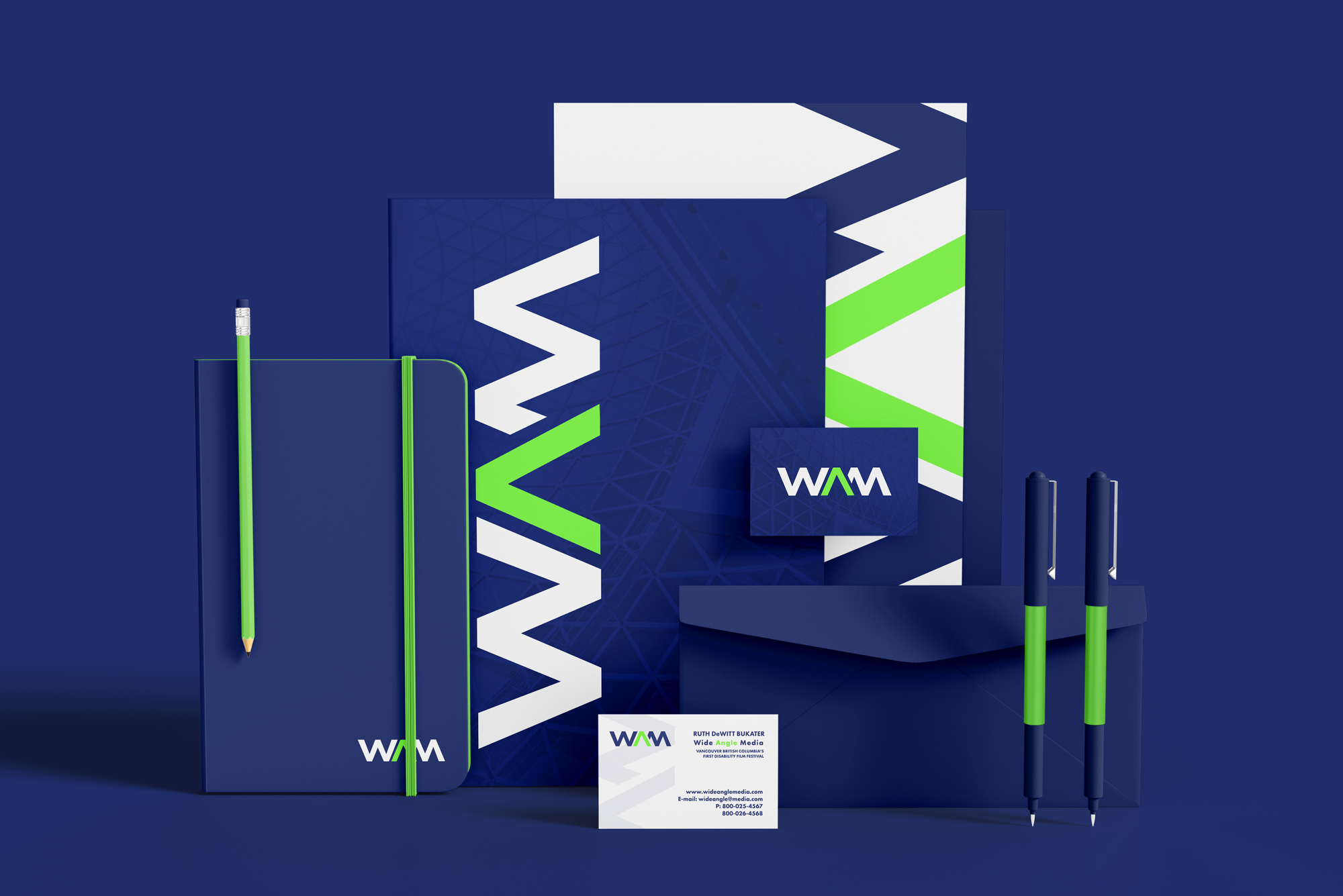 Set of branded stationery items, including a notebook, pens, business card, booklet, and folders in blue, green, and white colors, displaying the WAM logo.