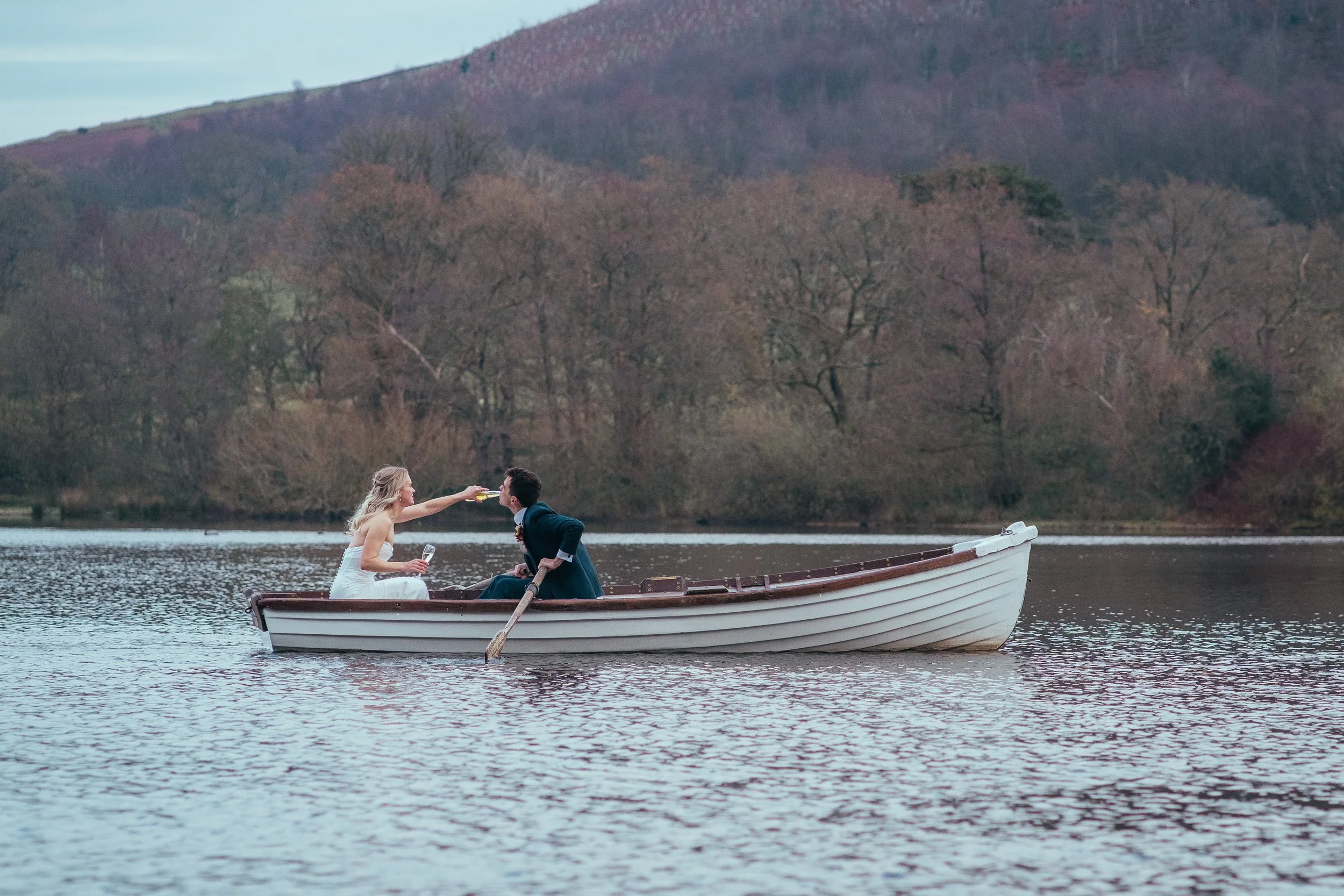 Bride and groom on a boat with celebratory drinks. 