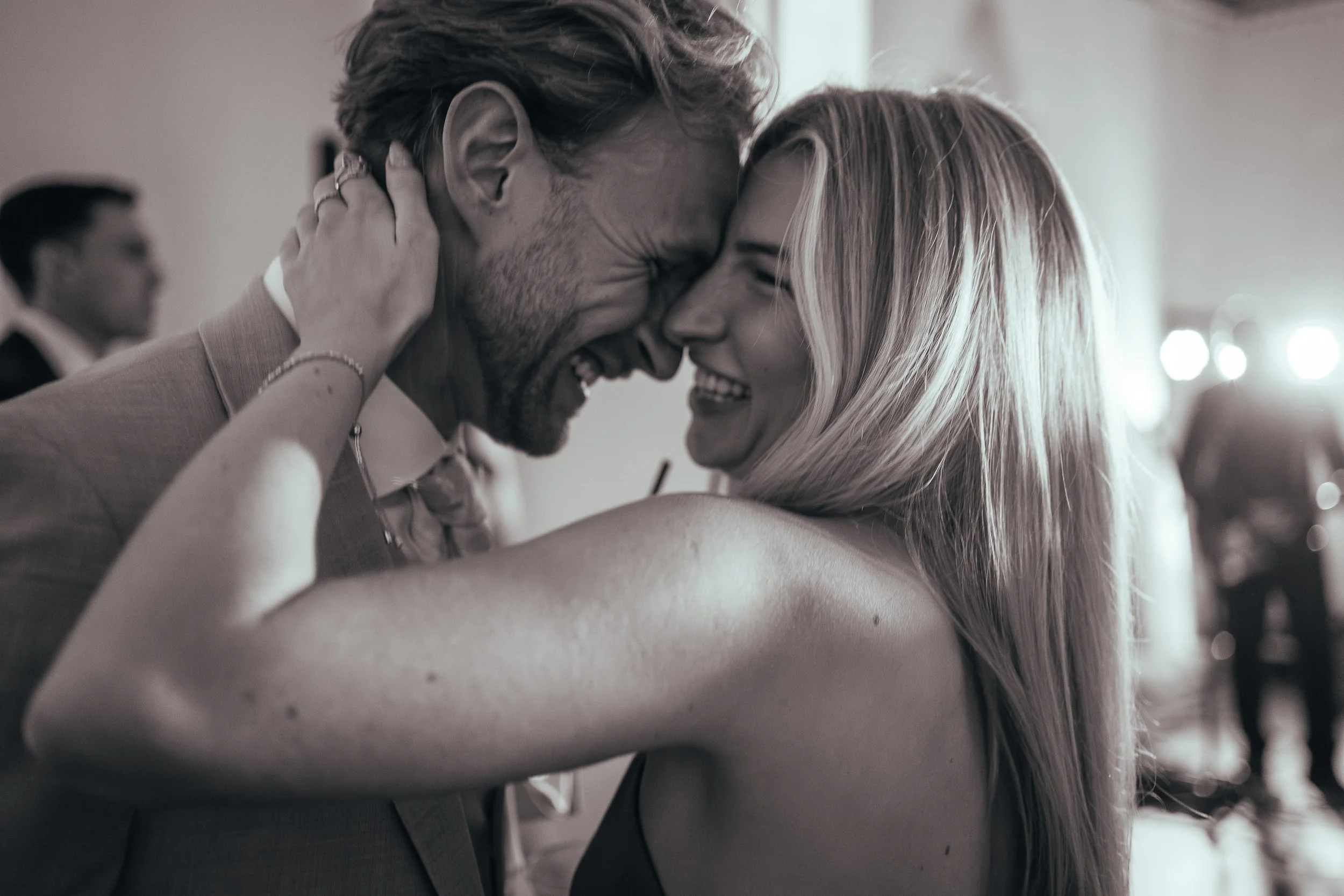 Laughing and embracing wedding guests. 