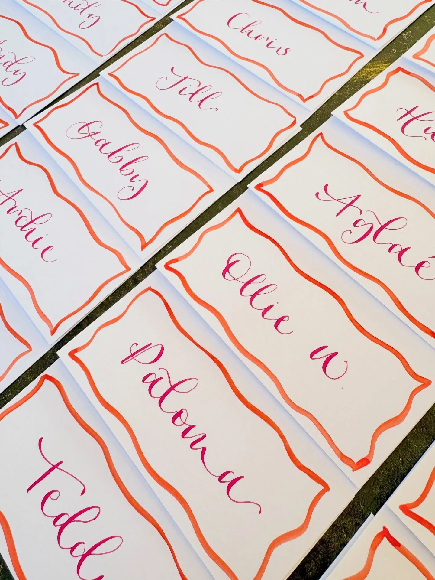 P L A C E C A R D S 💕 hot pink ink with hand painted orange borders bringing the sunshine to a winter wedding 🧡 
&bull;
&bull;
#weddingstationery #onthedaystationery #calligraphy