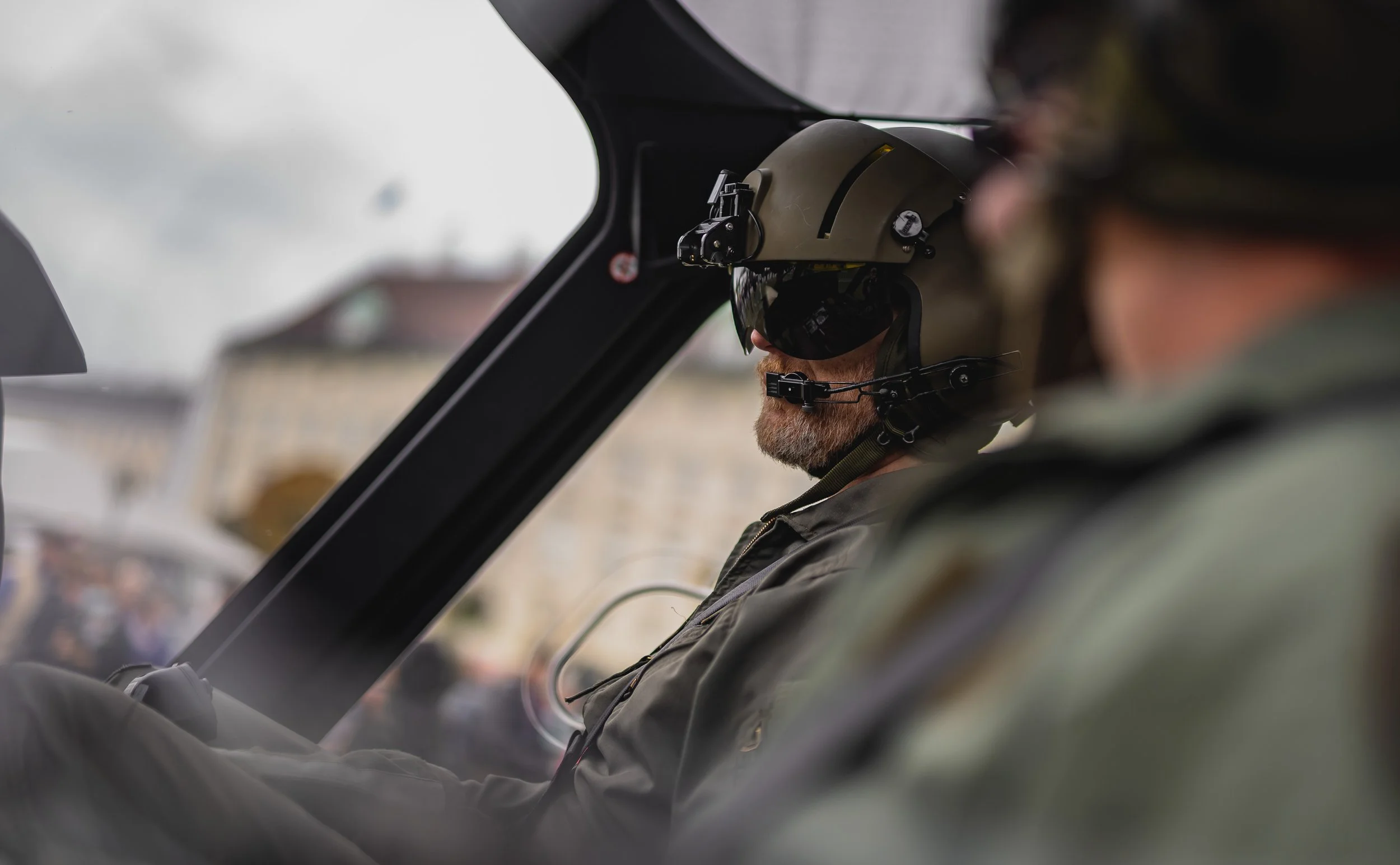 Pilot trägt Helm und Sonnenbrille im Cockpit eines Flugzeugs