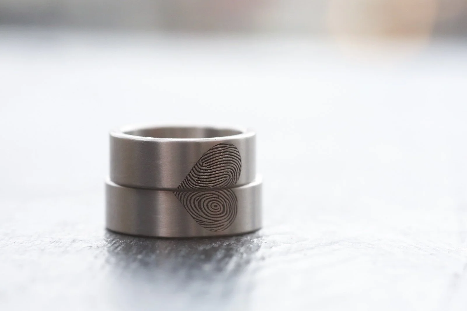 Bekijk deze trouwfoto waarop het bruidspaar hun unieke vingerafdrukringen bewondert, vervaardigd door [Uw Bedrijfsnaam]. Onze handgemaakte ringen, met de vingerafdruk van uw partner, symboliseren de bijzondere band die u deelt. Als specialist in gepe