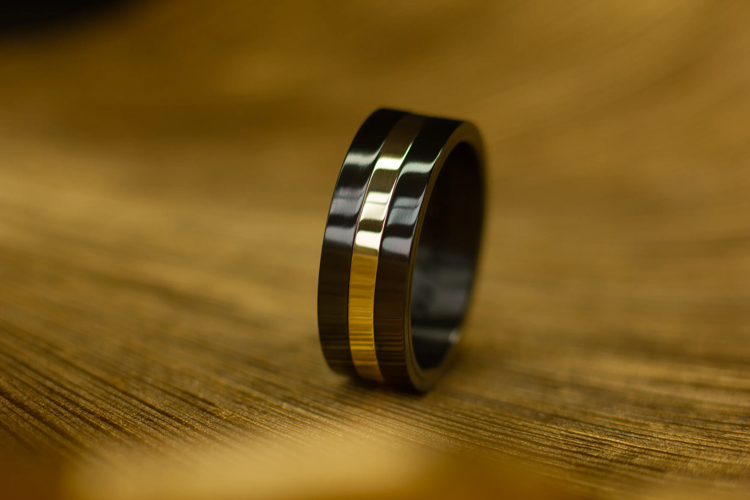 Zwarte zirkonium ring met gouden band. Zwarte trouwringen, bijzondere trouwringen, speciale trouwringen, black and gold 22223311-geconverteerd-van-png.webp