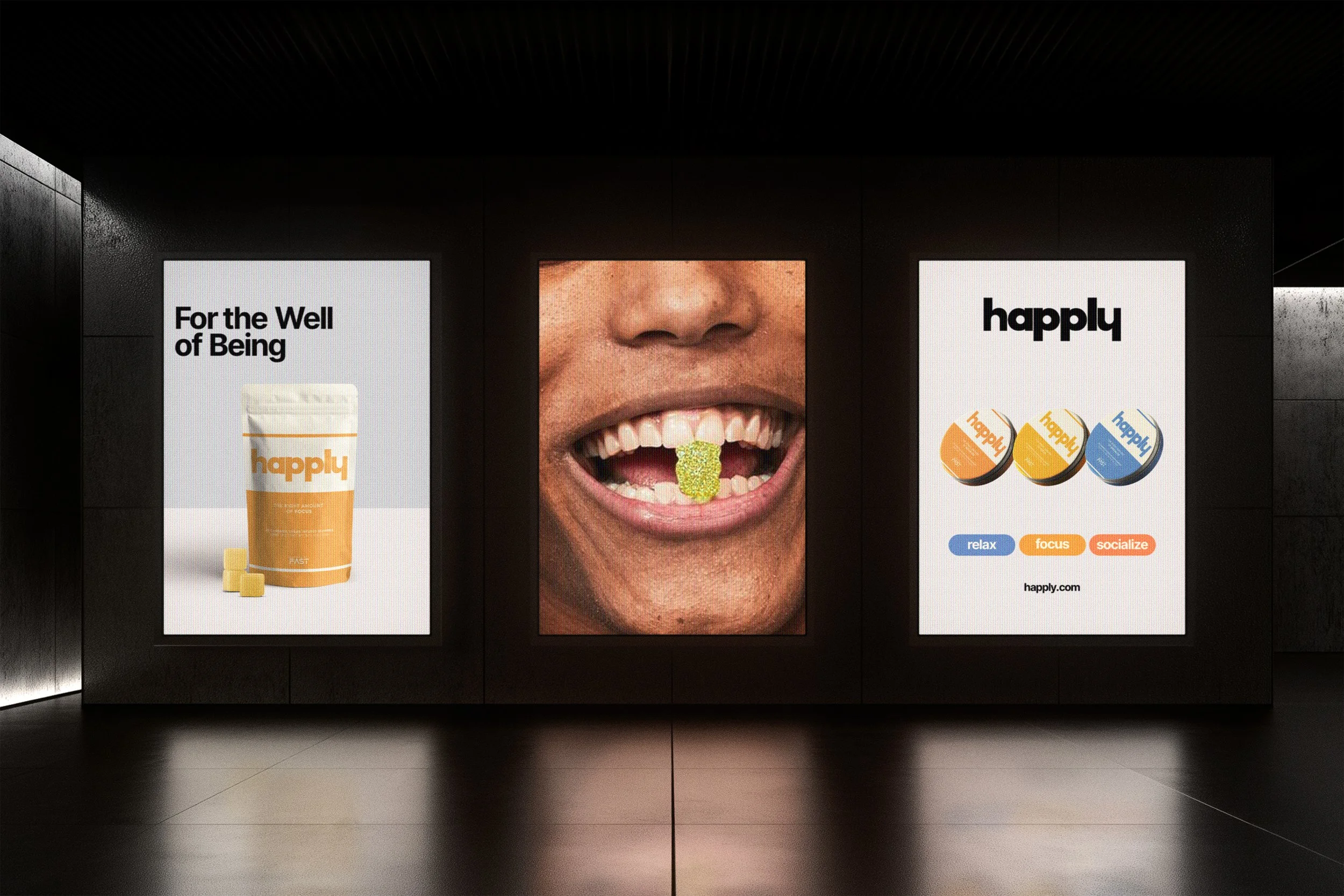 Three advertisements on a wall; the left promotes a supplement called 'Happily' with the tagline 'For the Well of Being,' showing a container and some tablets; the middle is a close-up of a person's mouth with a gummy vitamin or supplement on the tongue; the right advertises 'Happily' products, featuring three colorful packages labeled 'relax,' 'focus,' and 'socialize,' with the URL happily.com.