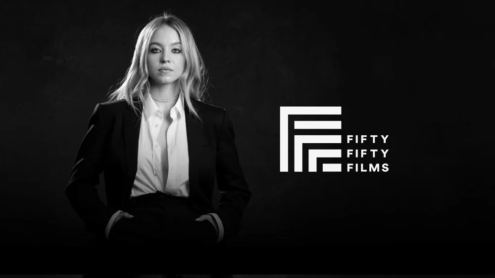 A black-and-white photo of a woman in a business suit, standing with her hands in her pockets. To the right is a logo with the text "Fifty Fifty Films."