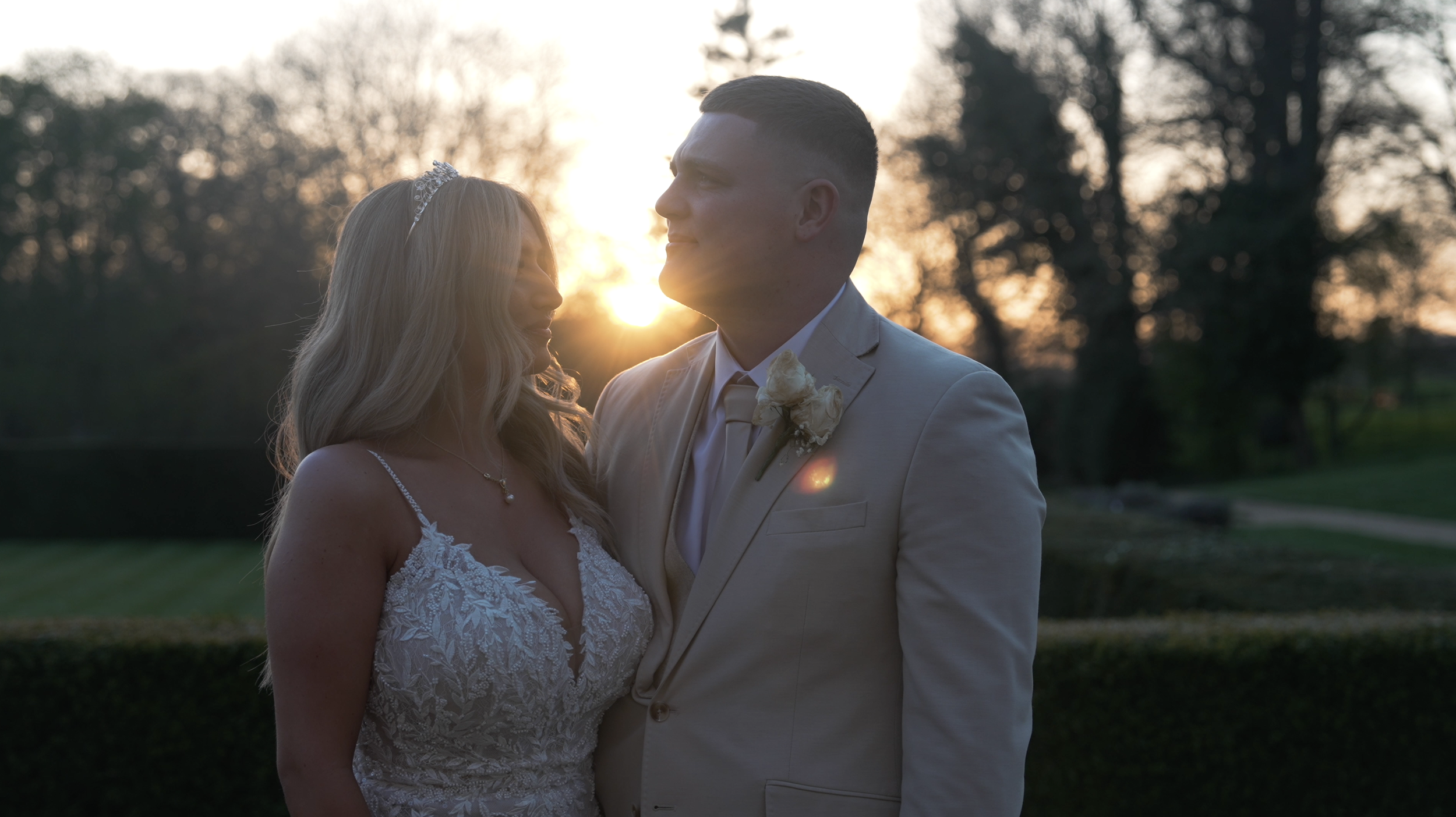 Cinematic golden hour moment of a couple at Rushton Hall with warm natural sunlight, creamy tones and romantic atmosphere captured by James David Films.