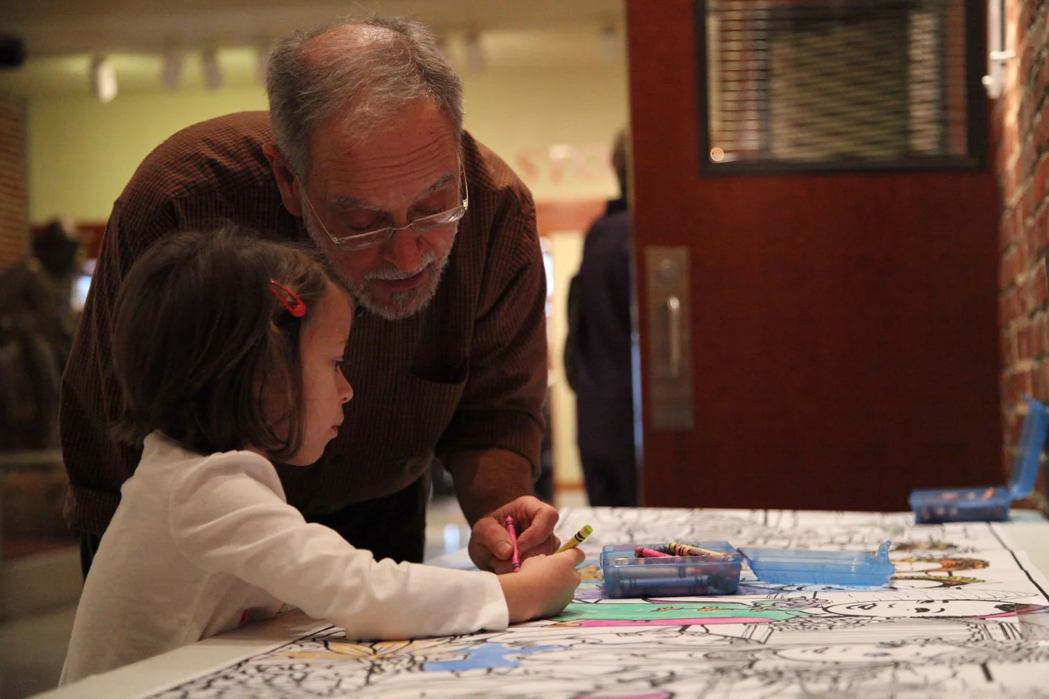 A grandfather and child coloring together
