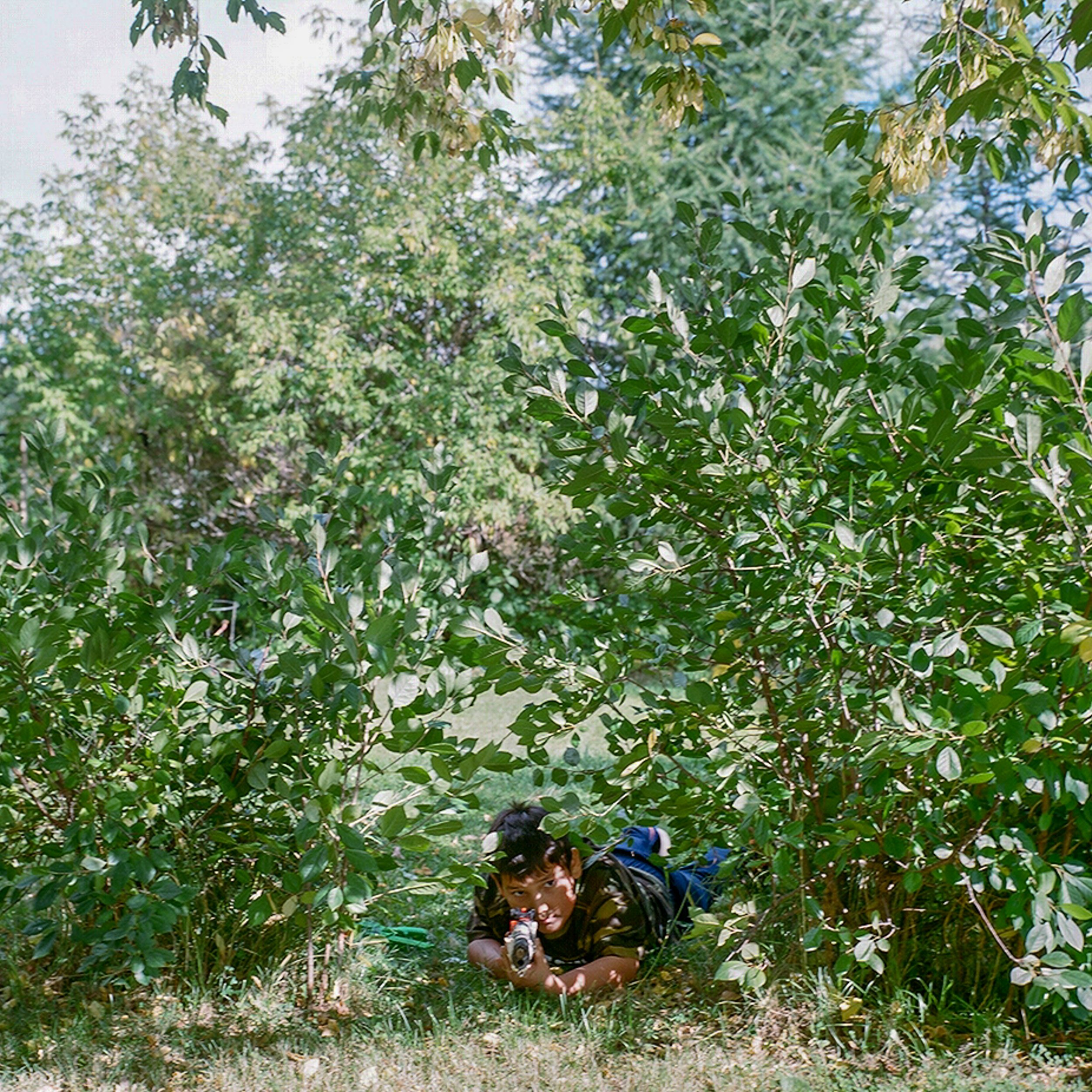 Elder Alice Rigney's grandson Ian plays on Rigney's property with a fake gun in Fort Chipewyan.