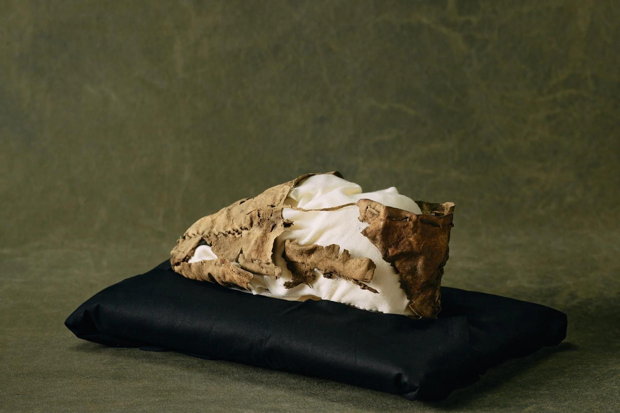 Careful stitching and hide construction define this 1,400-year-old moccasin, reflecting Dene design traditions within the traditional territories of the Champagne and Aishihik First Nations. It speaks to the long presence of people who travelled thes